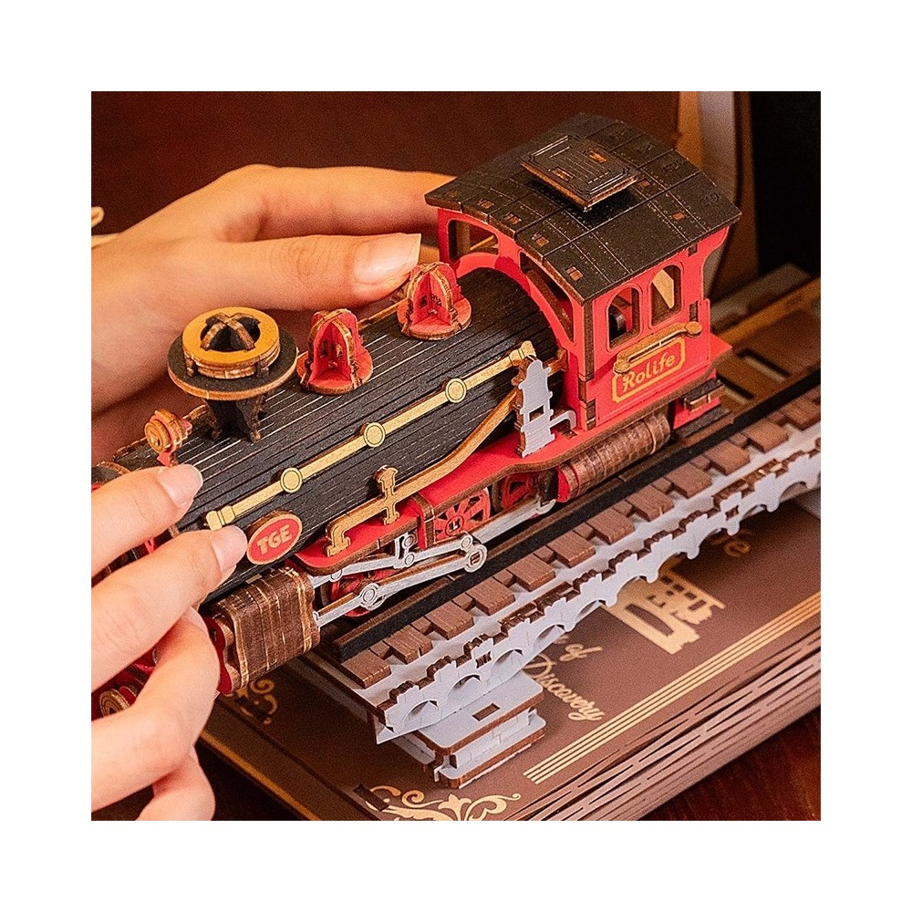 Eller ray üzerinde kırmızı ve siyah ahşap model treni monte ediyor.