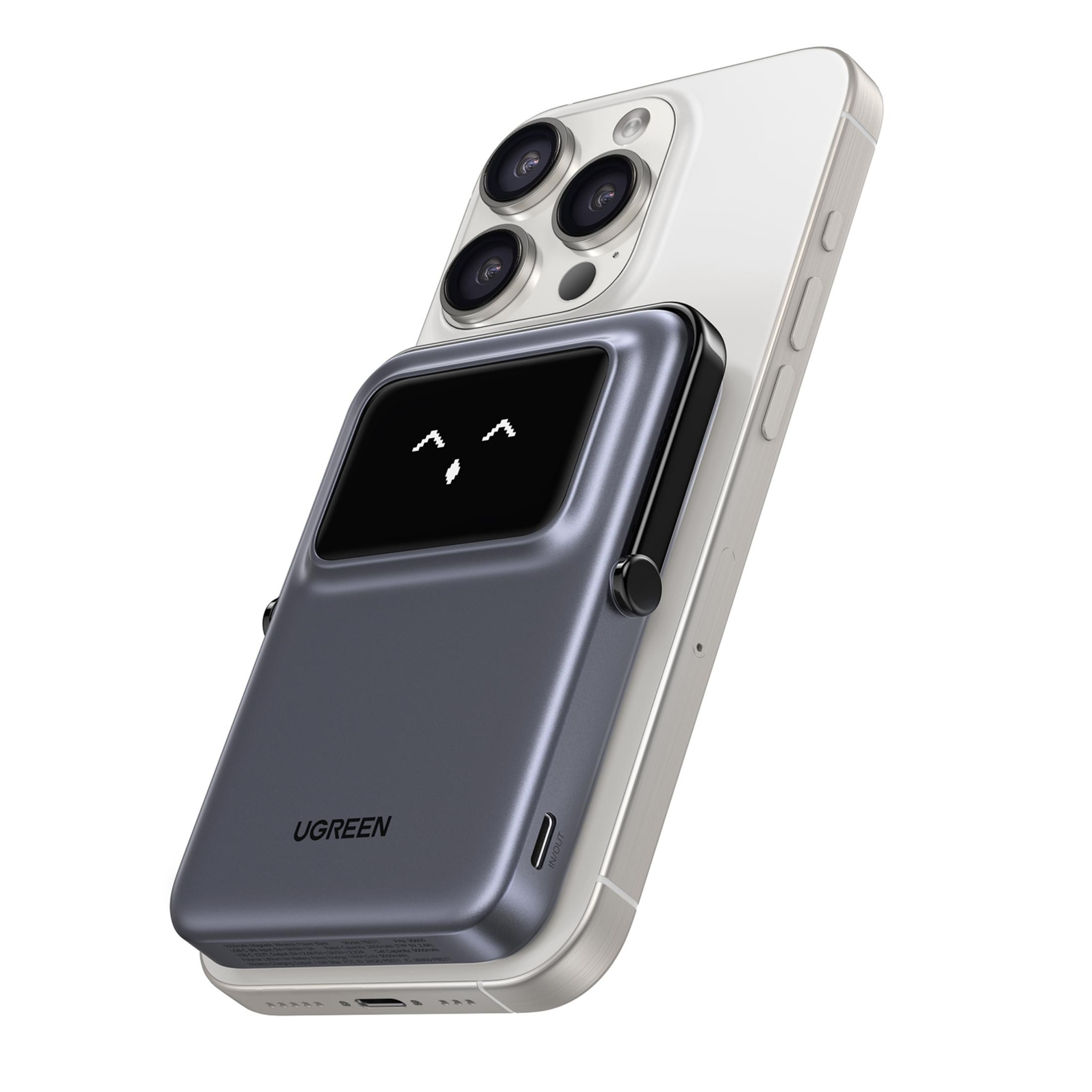 Un power bank UGREEN grigio con una faccina sorridente sullo schermo, attaccato a un iPhone bianco.