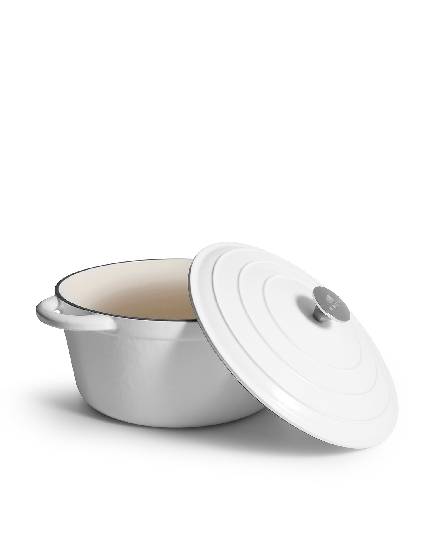 Una olla blanca de hierro fundido esmaltado con tapa, sobre fondo blanco.