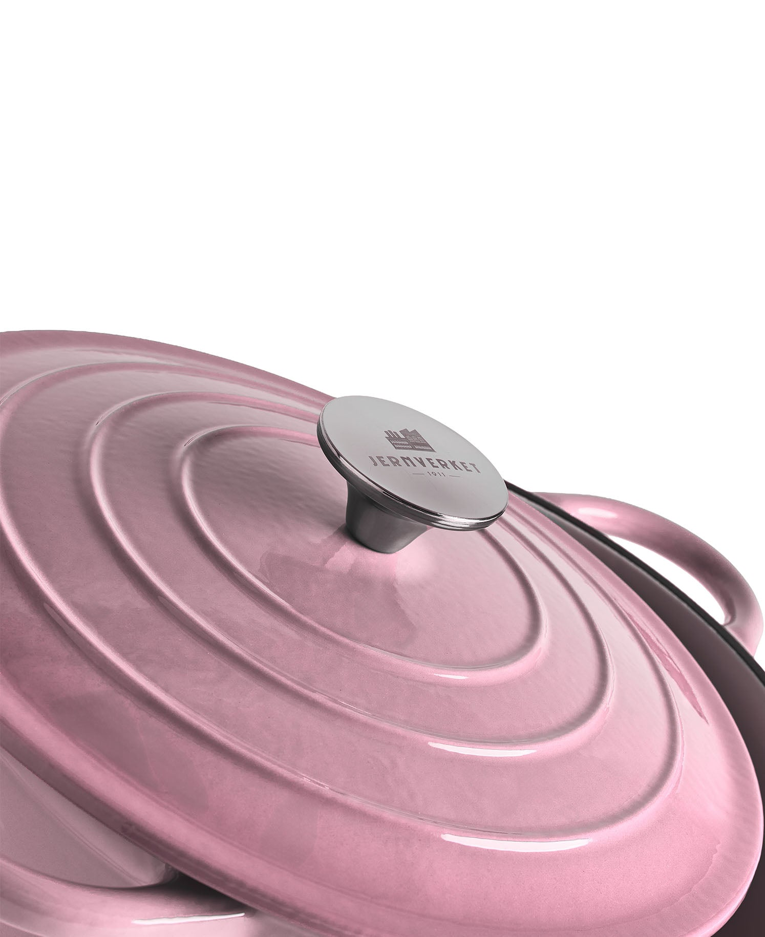 Una olla rosa con tapa acanalada y asa plateada.