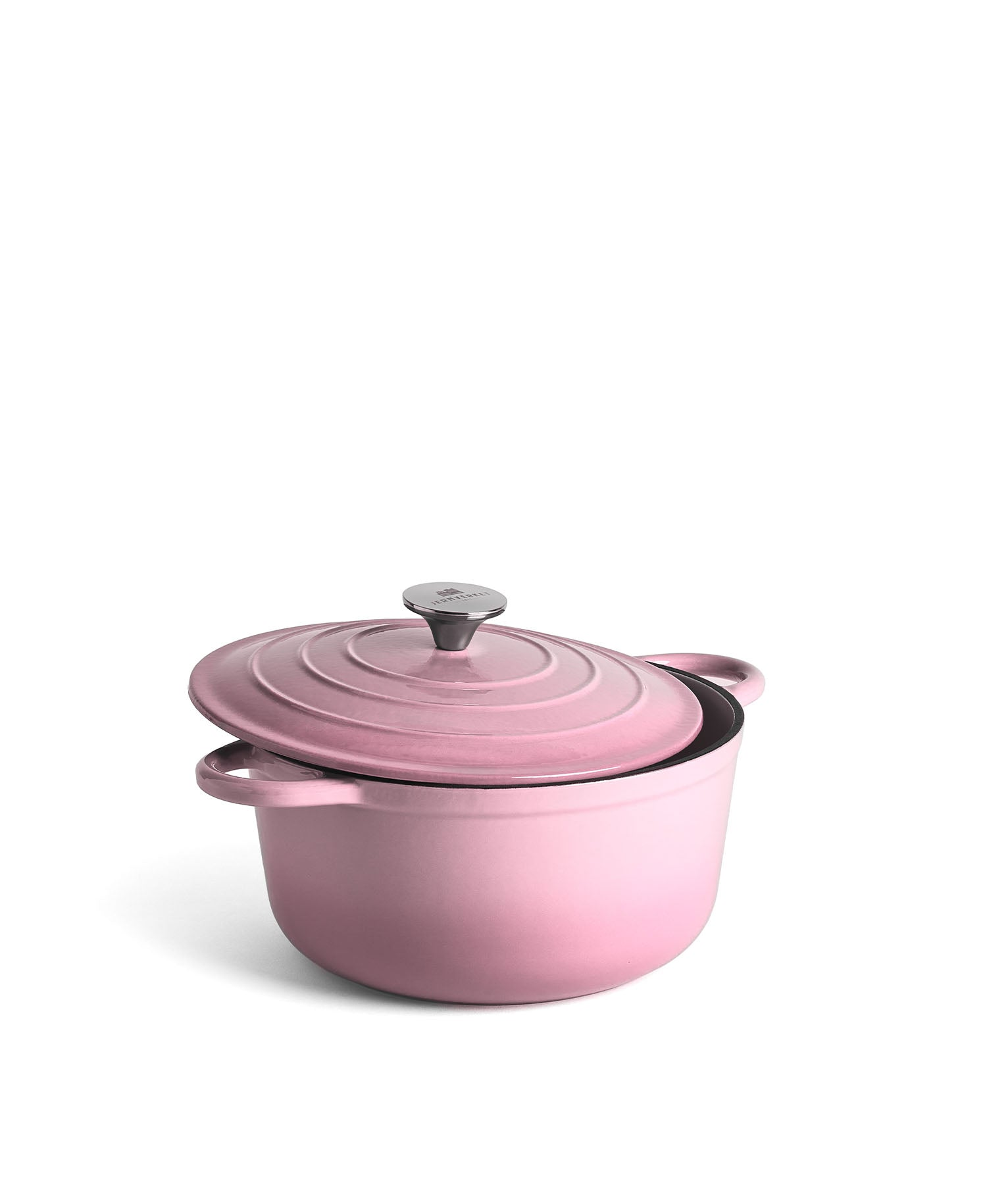 Una olla de hierro fundido rosa con tapa está sobre fondo blanco.