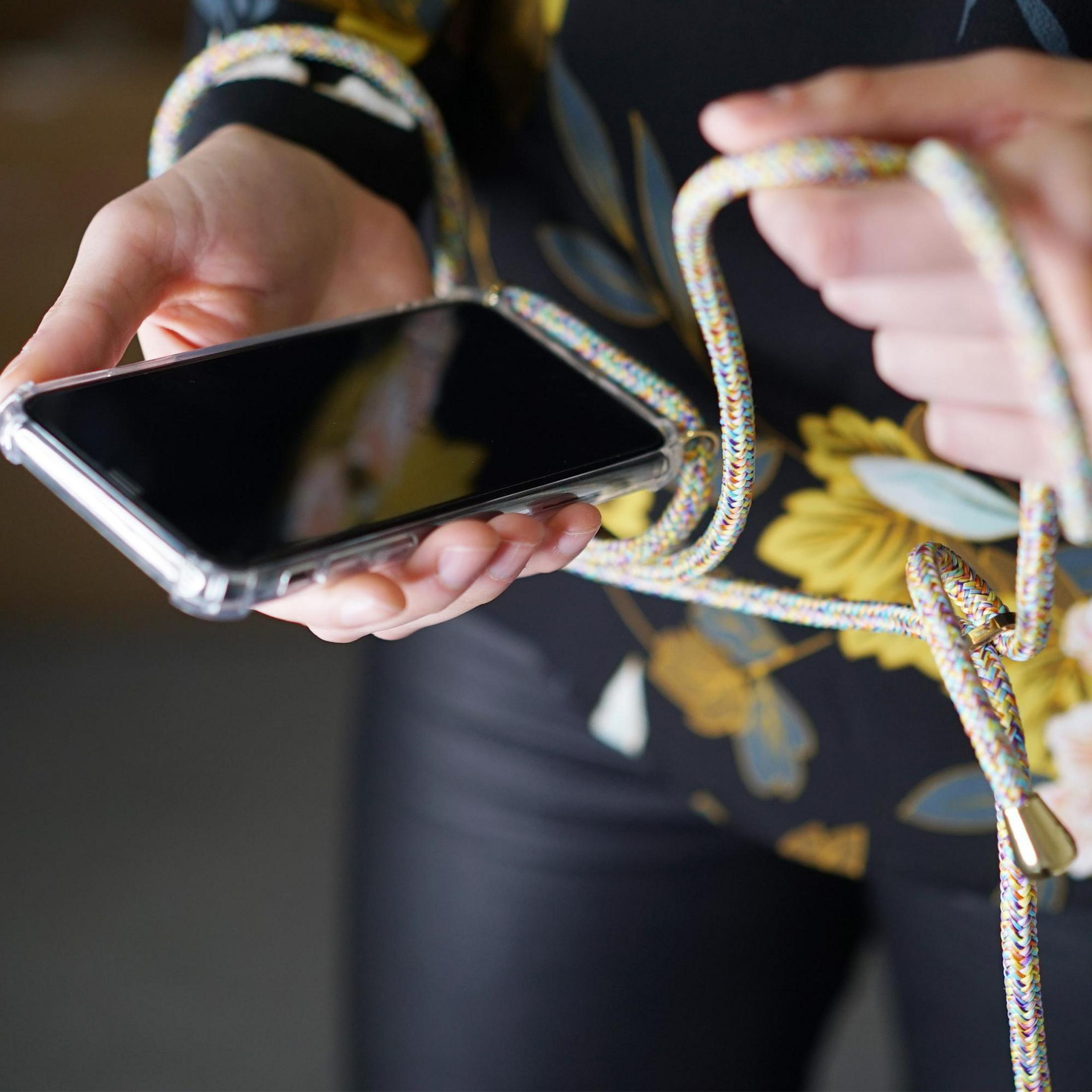 Eine Person hält ein Smartphone in einer transparenten Hülle mit einem bunten Band.