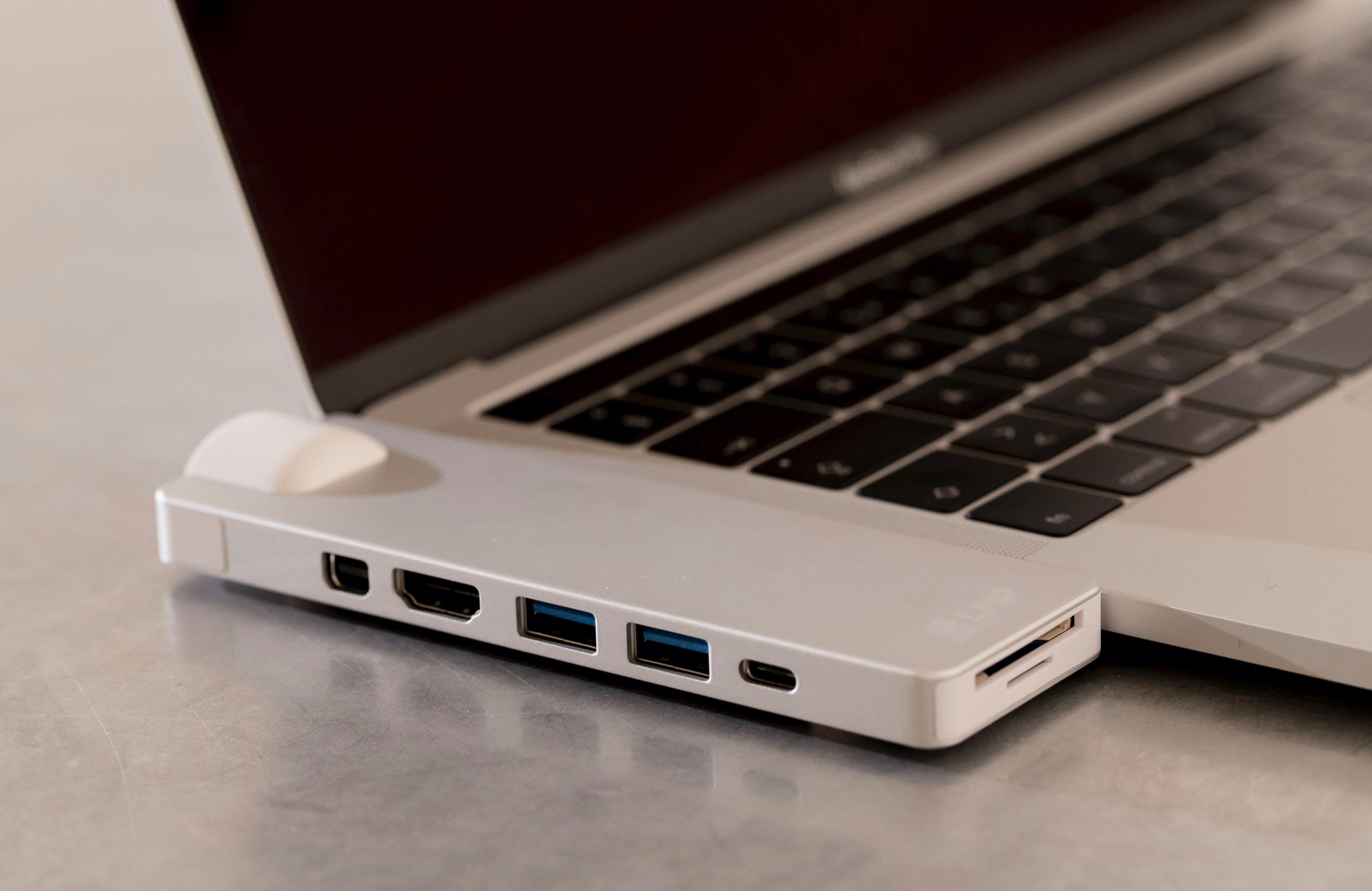 Un hub USB-C bianco con più porte collegato a un computer portatile.