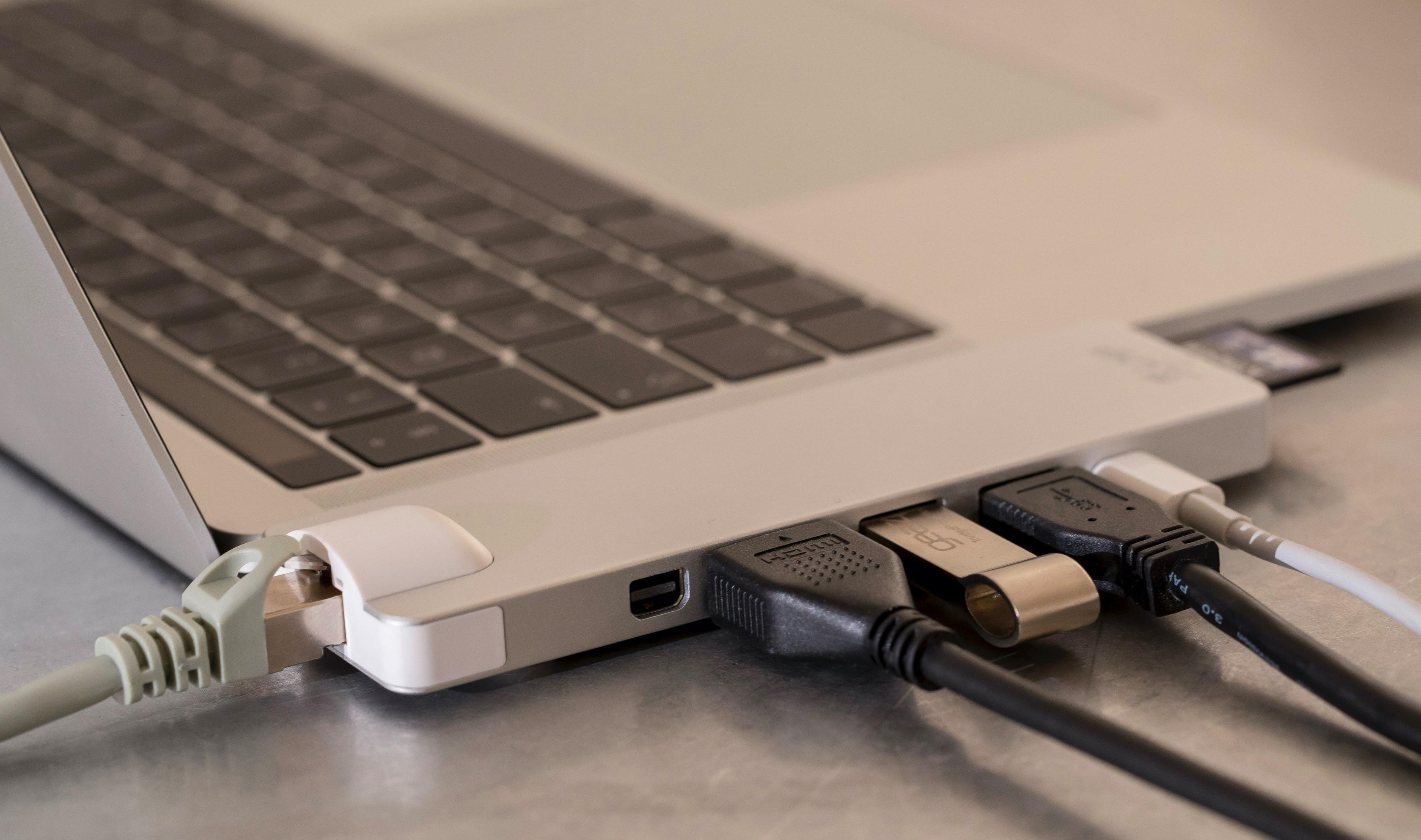 Laptop con cavi Ethernet, USB e HDMI collegati a un hub.