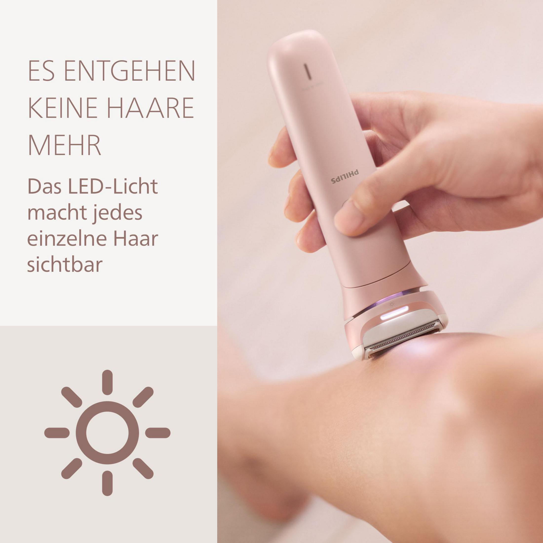 Un epilatore rosa con luce LED viene utilizzato su una gamba.