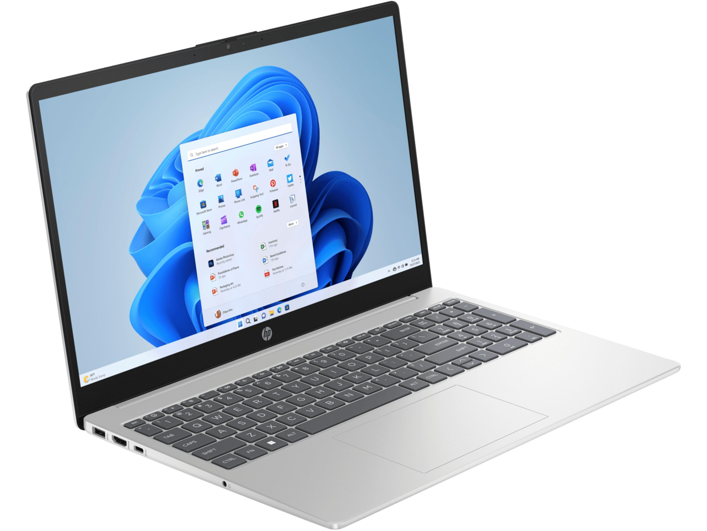 Un portátil HP plateado con la pantalla abierta, mostrando el menú de inicio de Windows 11.