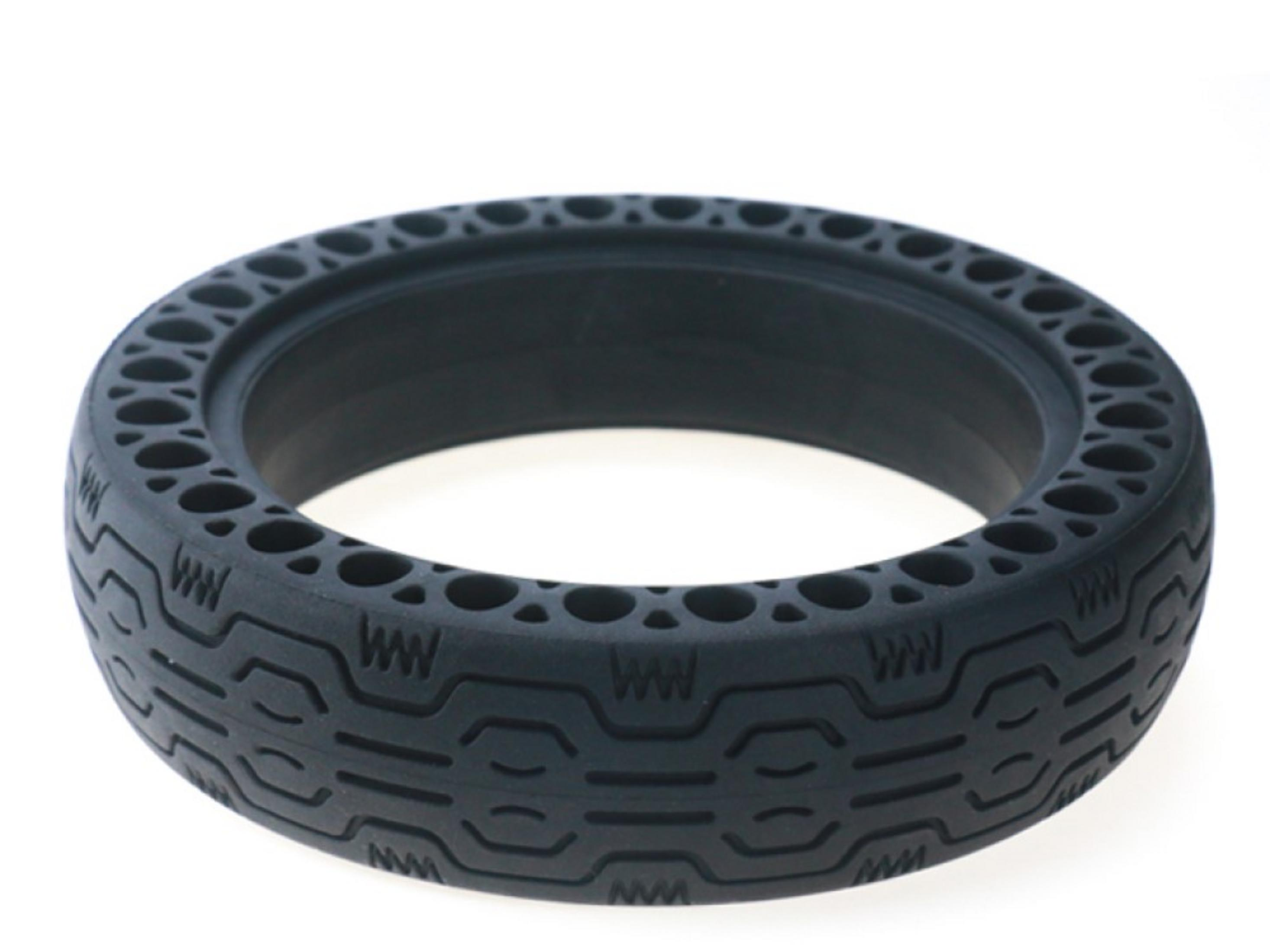 Un neumático negro con patrón de panal y bandas de rodadura geométricas sobre fondo blanco.