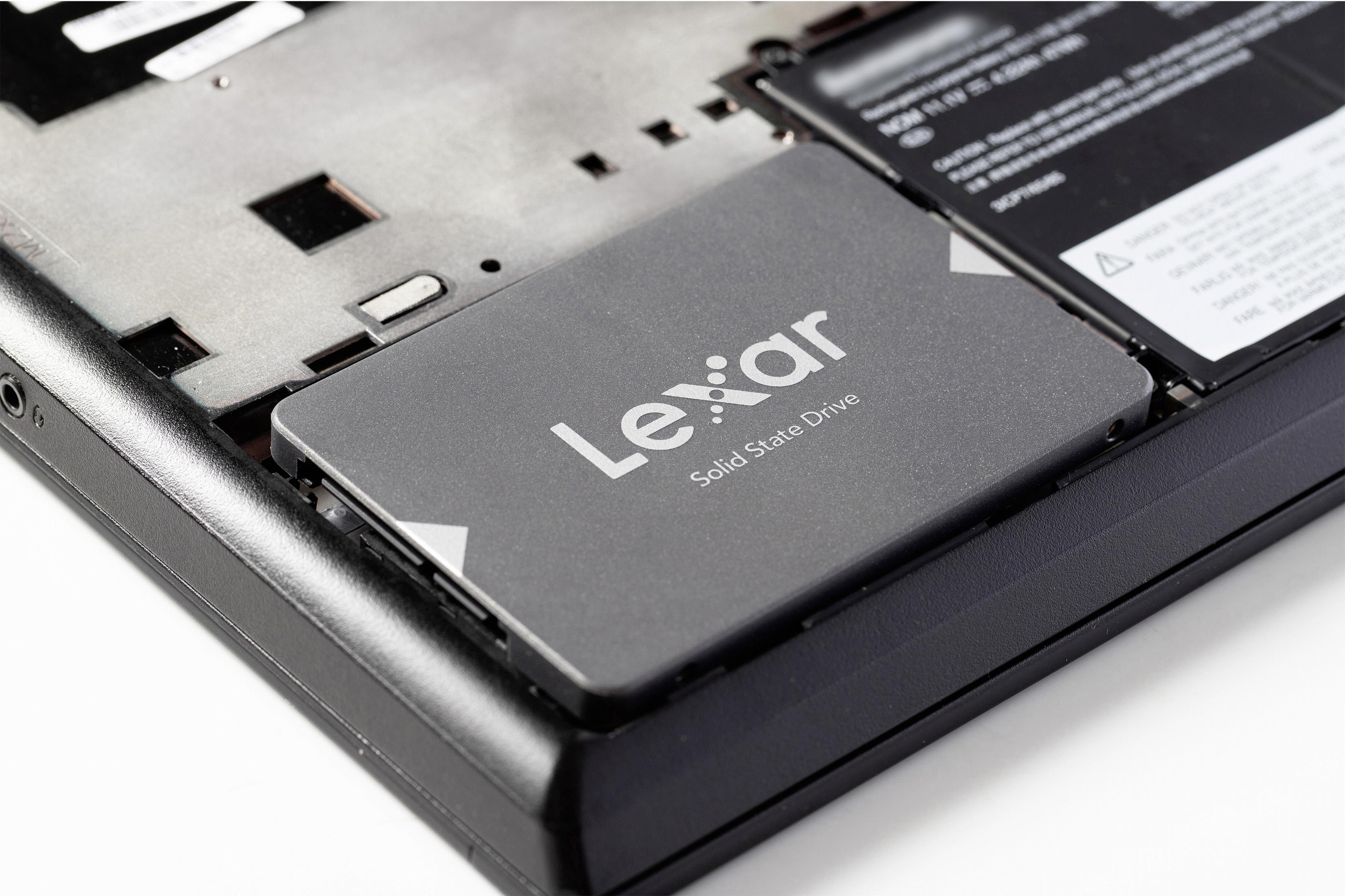 Dysk SSD Lexar w laptopie, obok baterii.