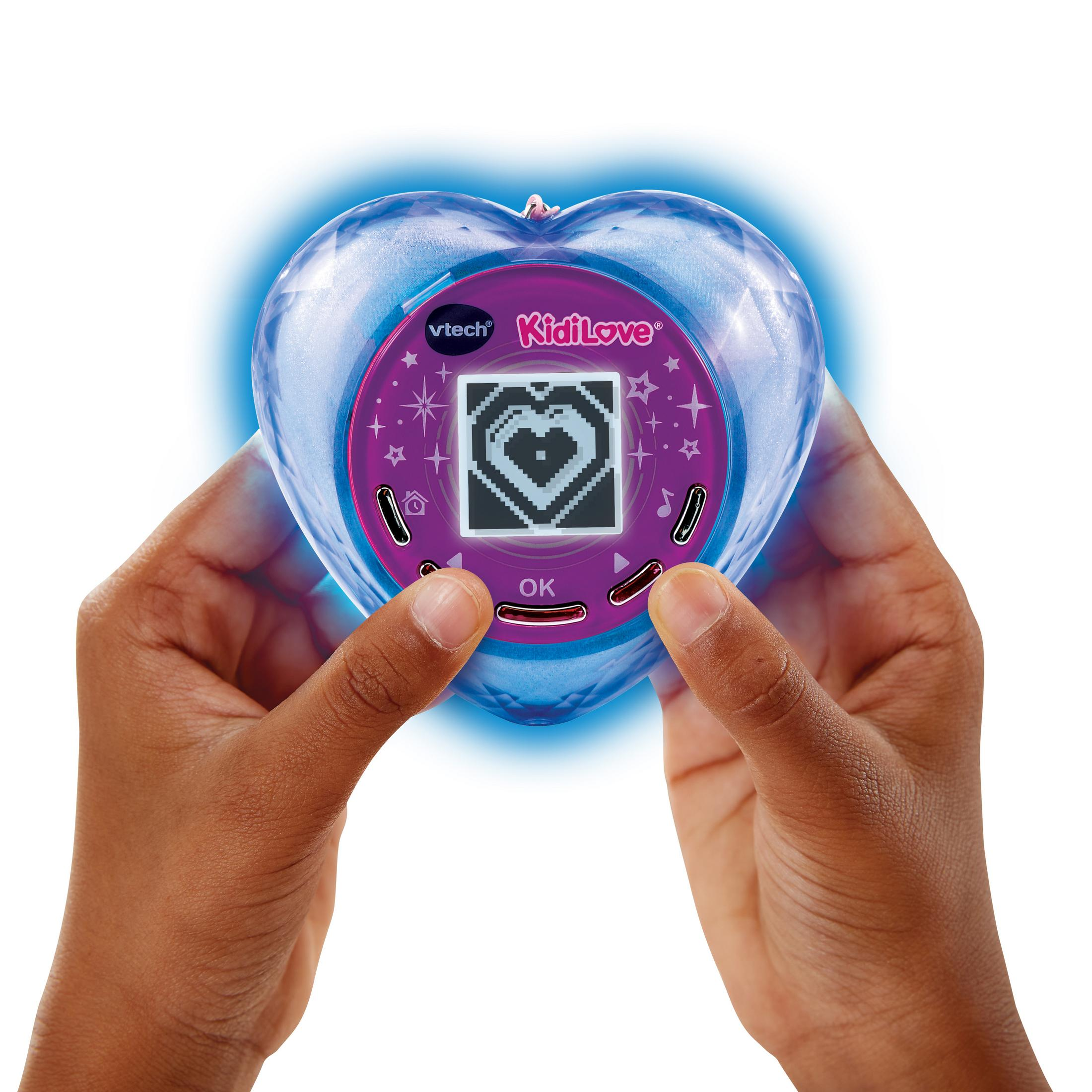 Zwei Hände halten ein herzförmiges Vtech KidiLove Spielzeug mit leuchtendem Rand.
