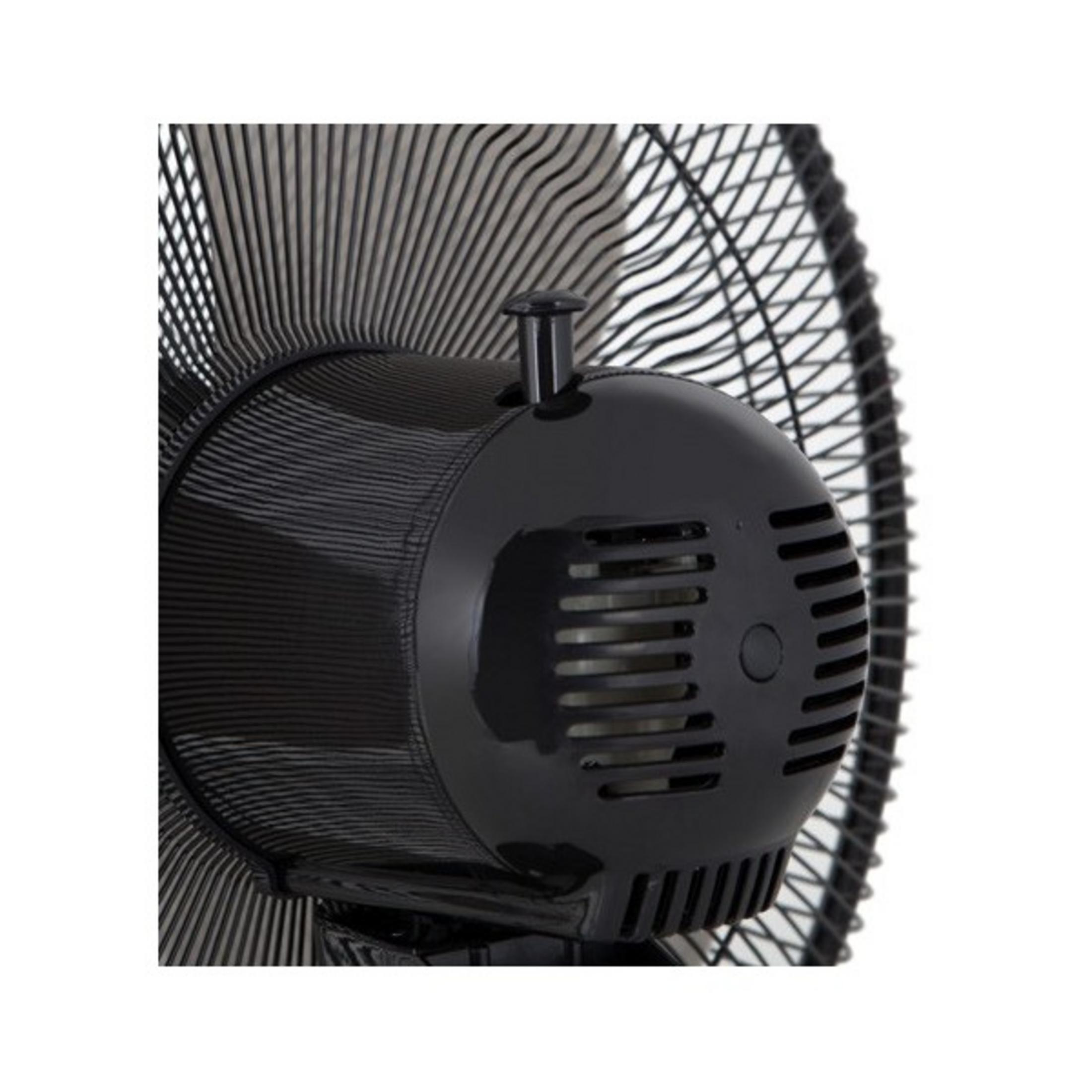 Primer plano de un ventilador negro. Se ven la carcasa del motor y la rejilla.