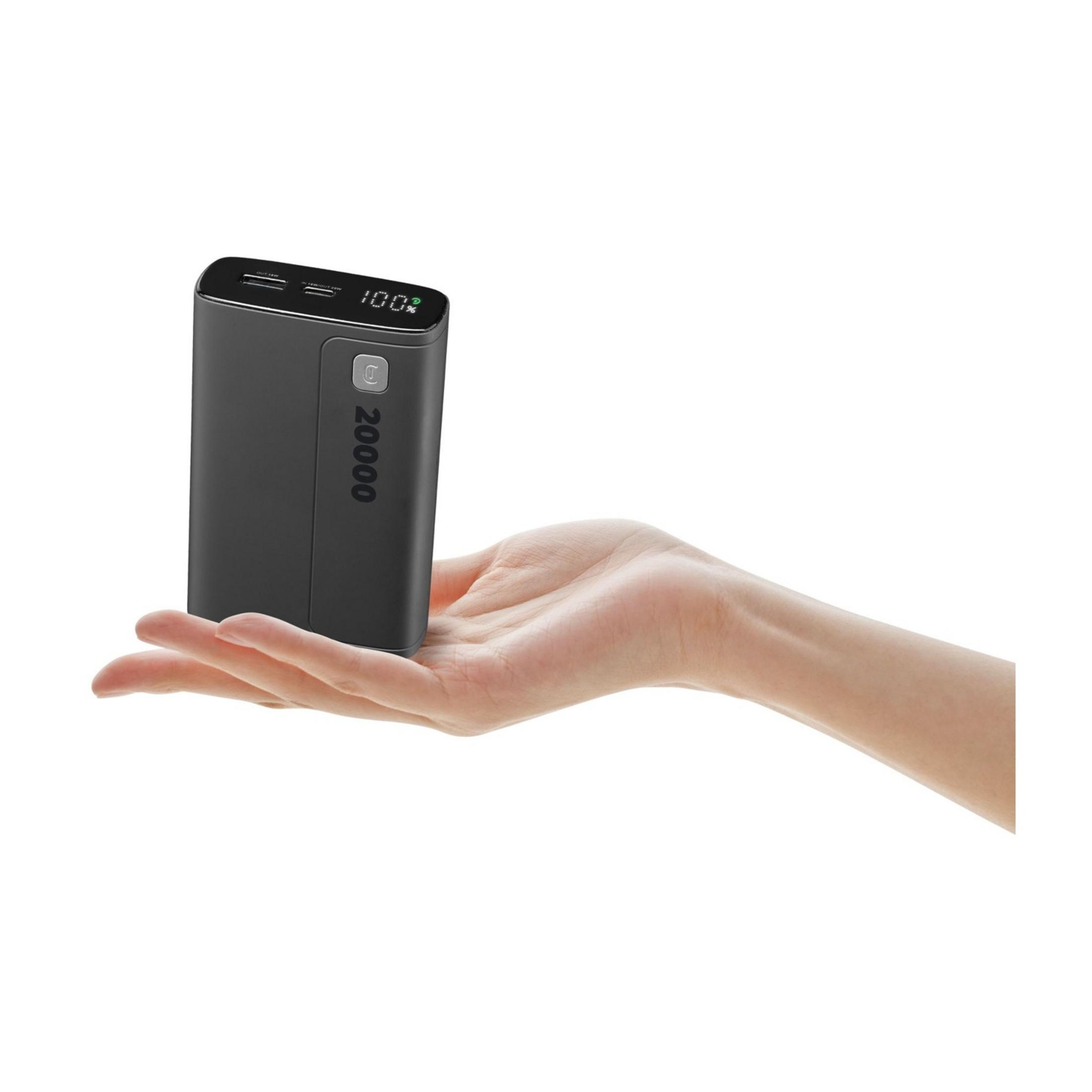 Ciemny power bank o pojemności 20000 mAh trzymany w dłoni, wyświetlacz pokazuje 100%.