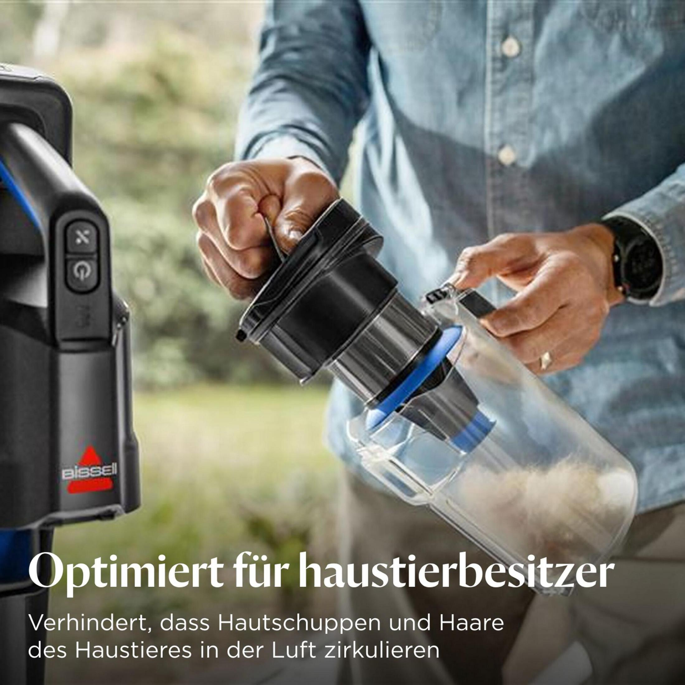 Ein Mann hält einen transparenten Staubbehälter mit Tierhaaren.