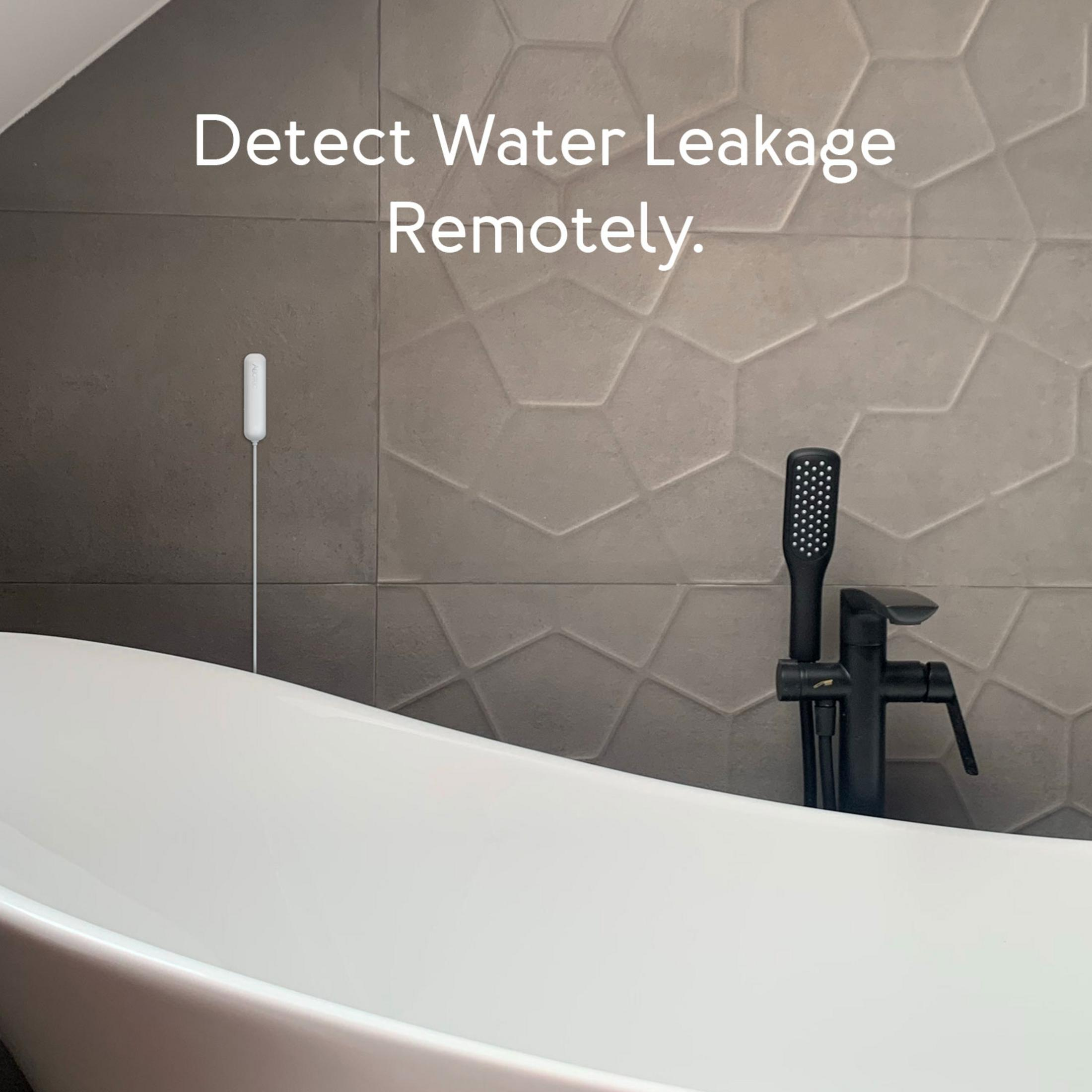 Ein weißer Wasserdetektor hängt an einer gefliesten Wand neben einer Badewanne.