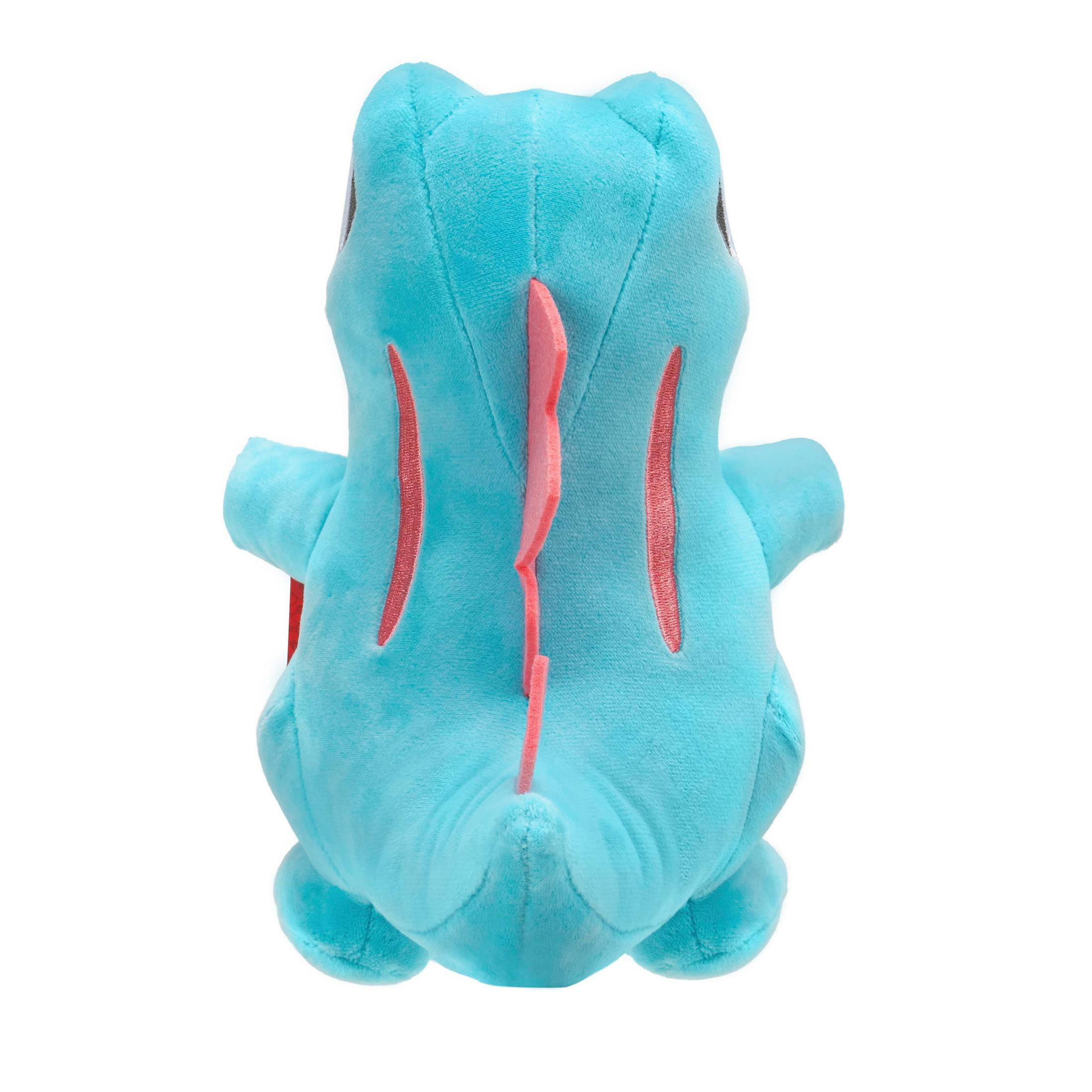 Ein blauer Plüschtier-Dinosaurier mit roten Streifen und einer roten Rückenflosse.