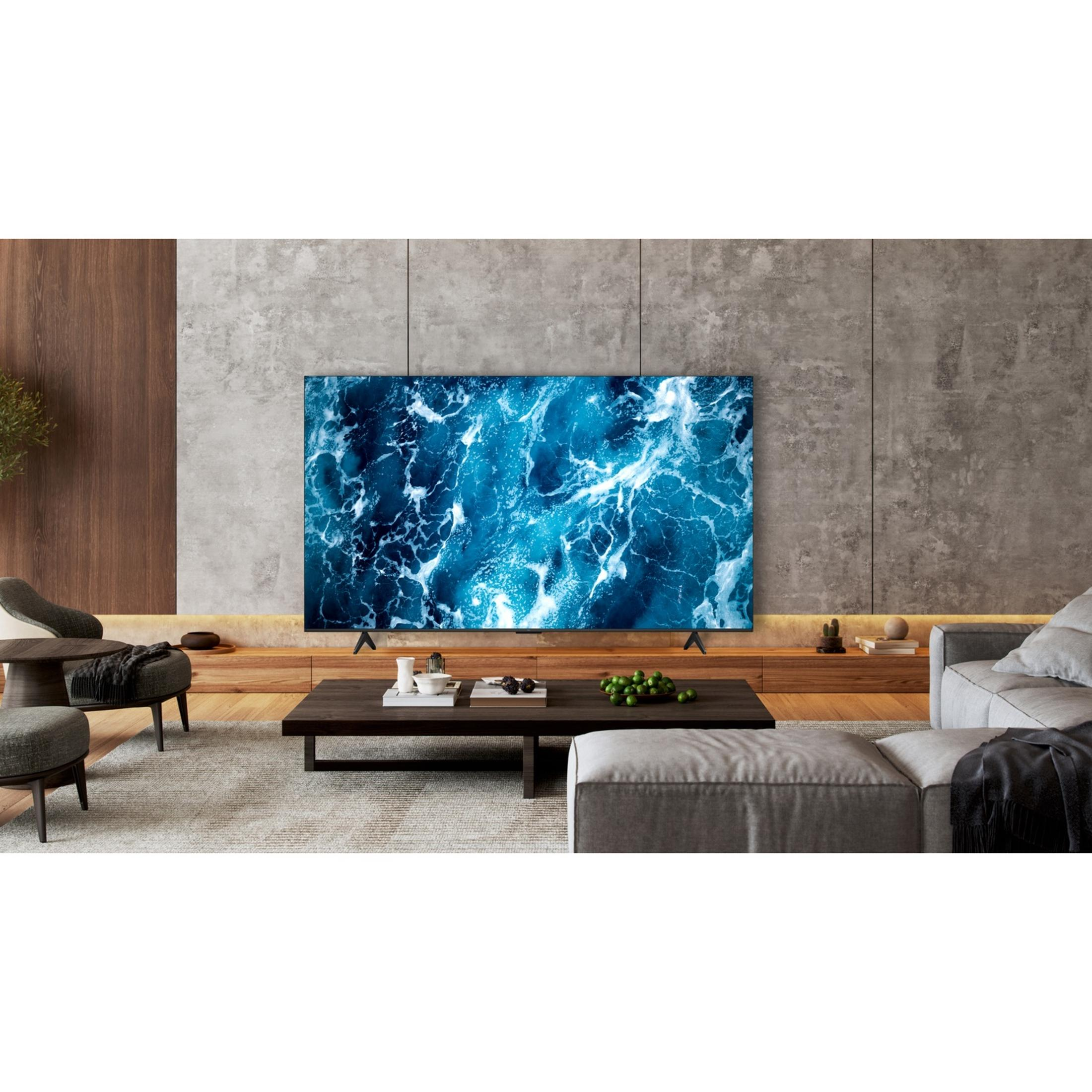 Un soggiorno moderno con un grande televisore che mostra una scena oceanica blu.