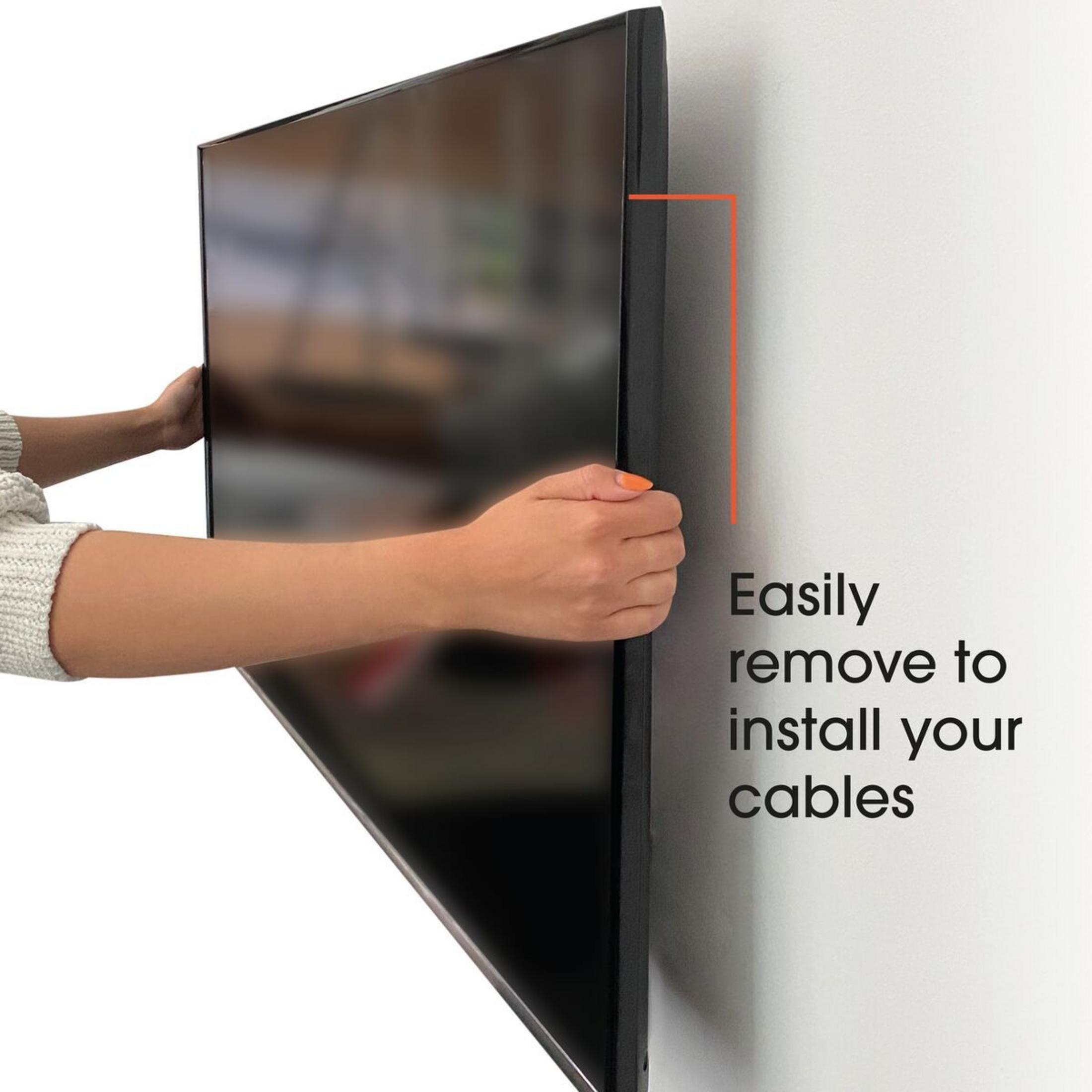 Eine Person zieht eine schwarze TV-Blende ab, um Kabel zu installieren.