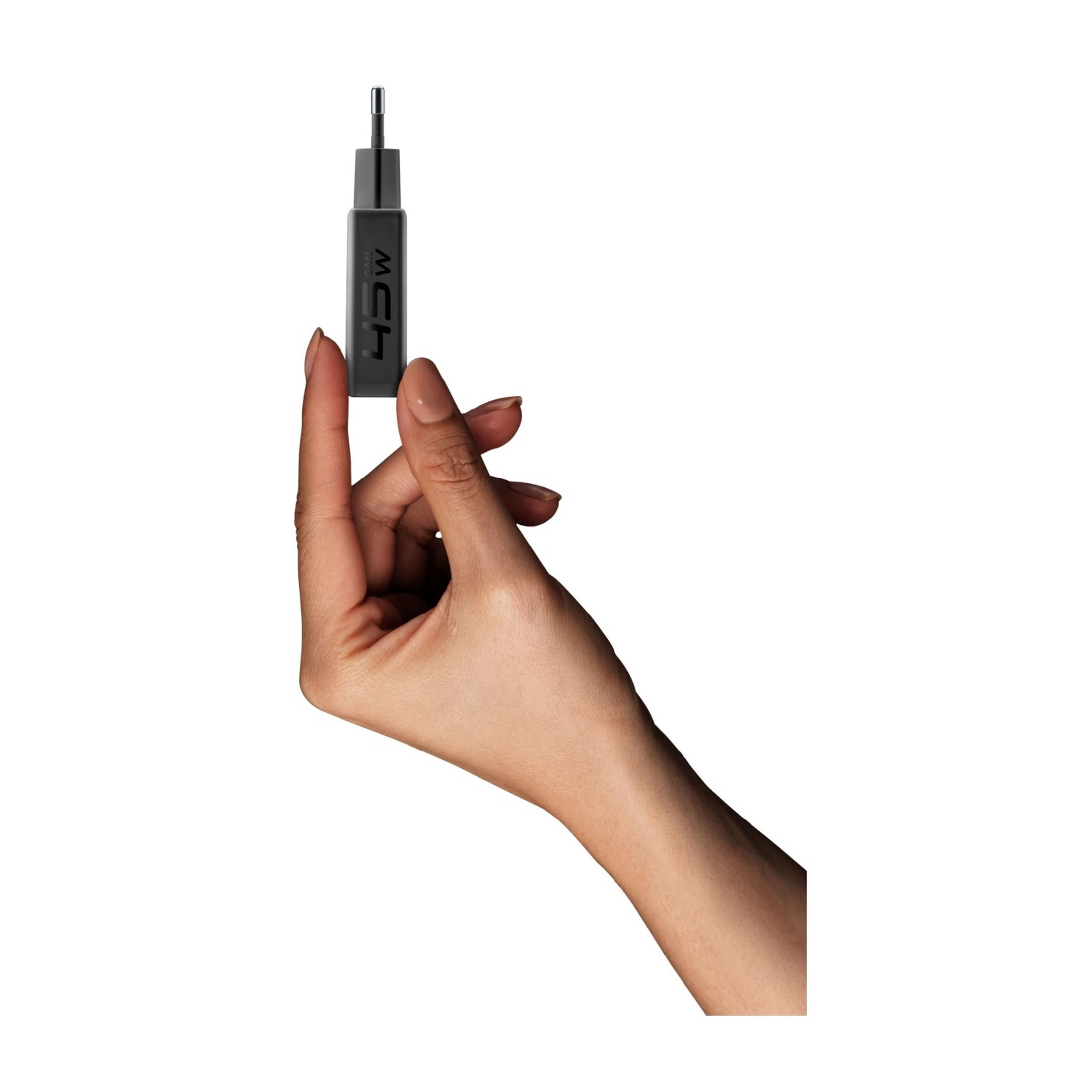 Eine Hand hält einen kleinen schwarzen Adapter mit der Aufschrift 45W.