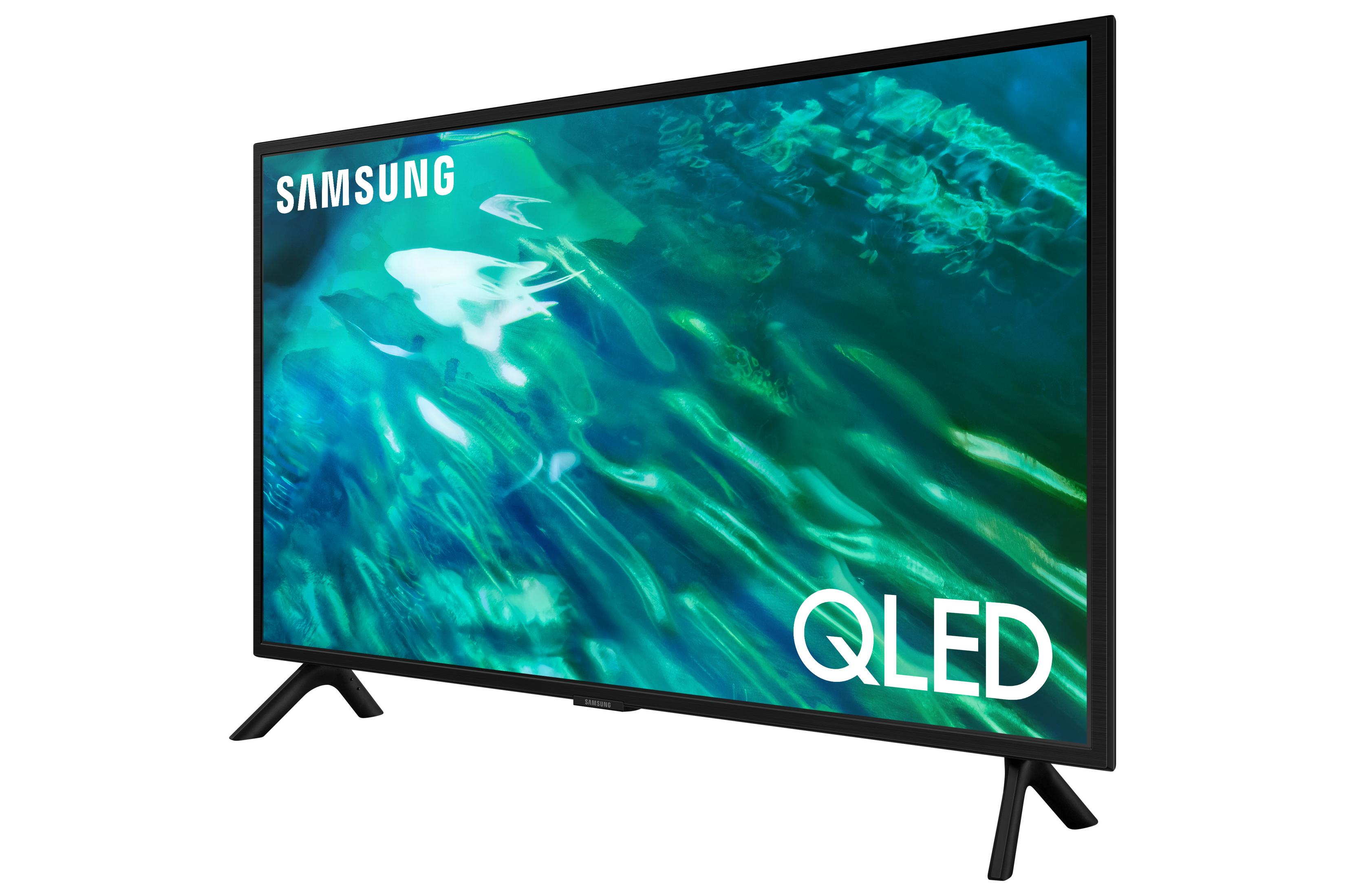 Un televisor Samsung QLED con marco y soporte negros, muestra olas verdes.