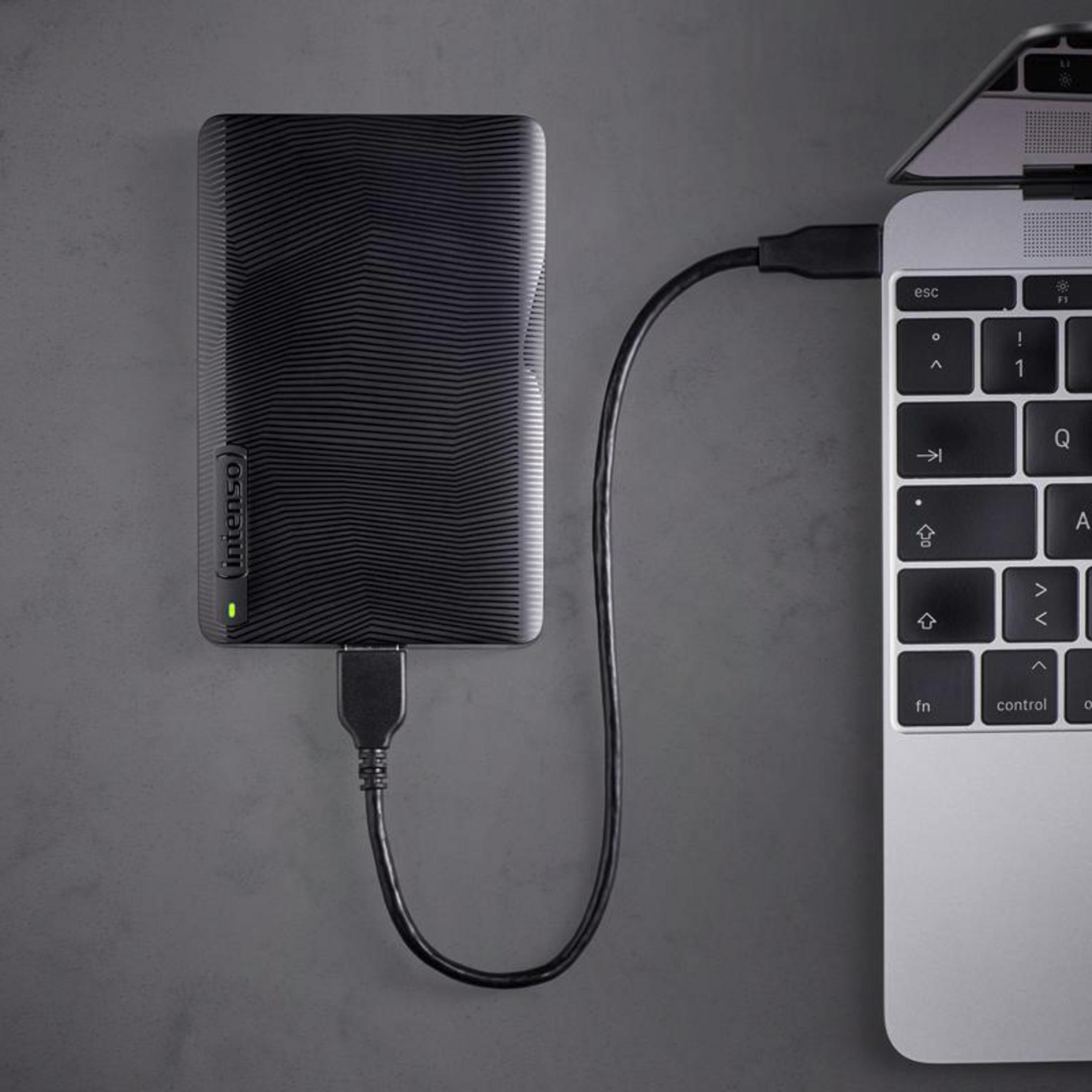 Hard disk esterno nero con motivo, collegato a un laptop.
