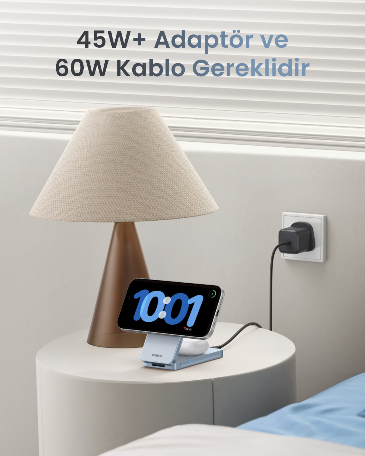 Szafka nocna z lampą, iPhone i stacją ładowania. Wtyczka w ścianie.