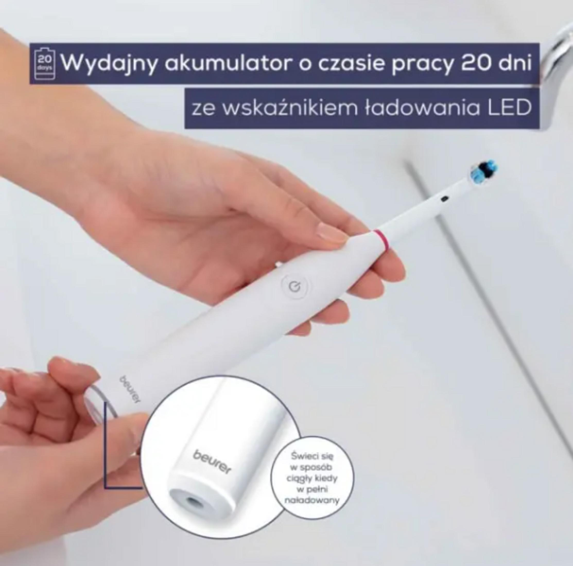 Brosse à dents électrique blanche avec indicateur de charge LED tenue par la main.