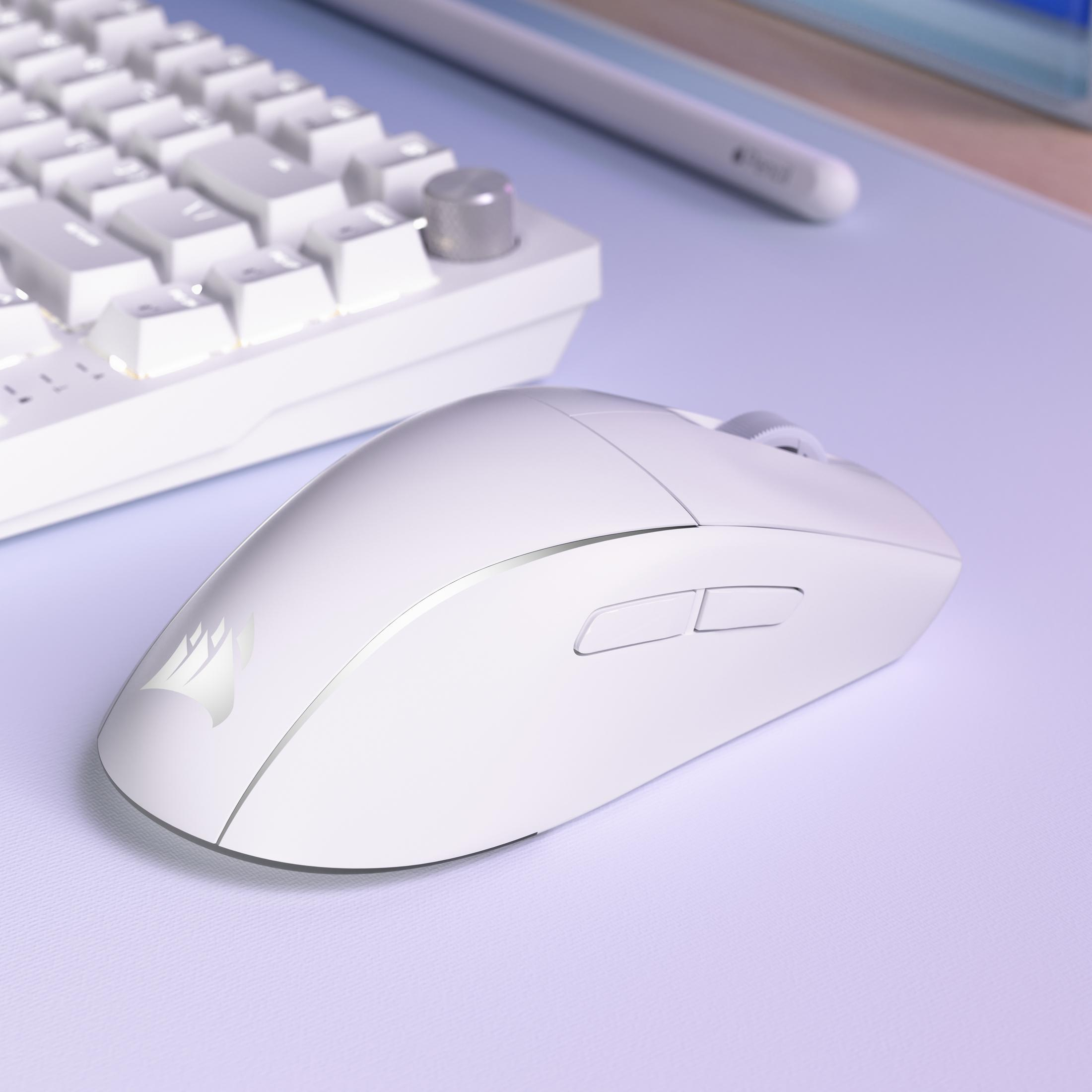 Un ratón gaming blanco junto a un teclado blanco sobre una alfombrilla morada.