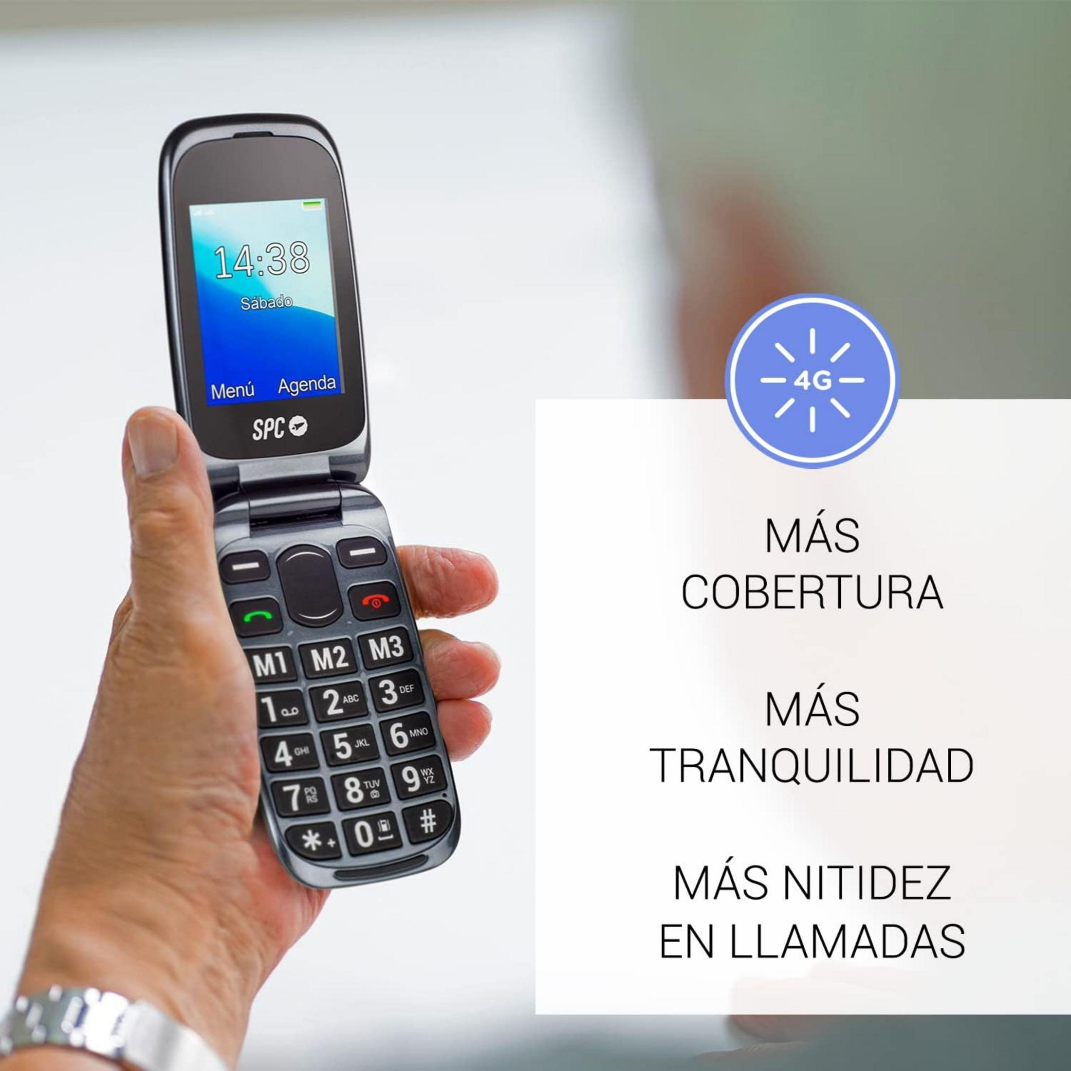 Una mano tiene un telefono flip aperto e argentato con tasti grandi.