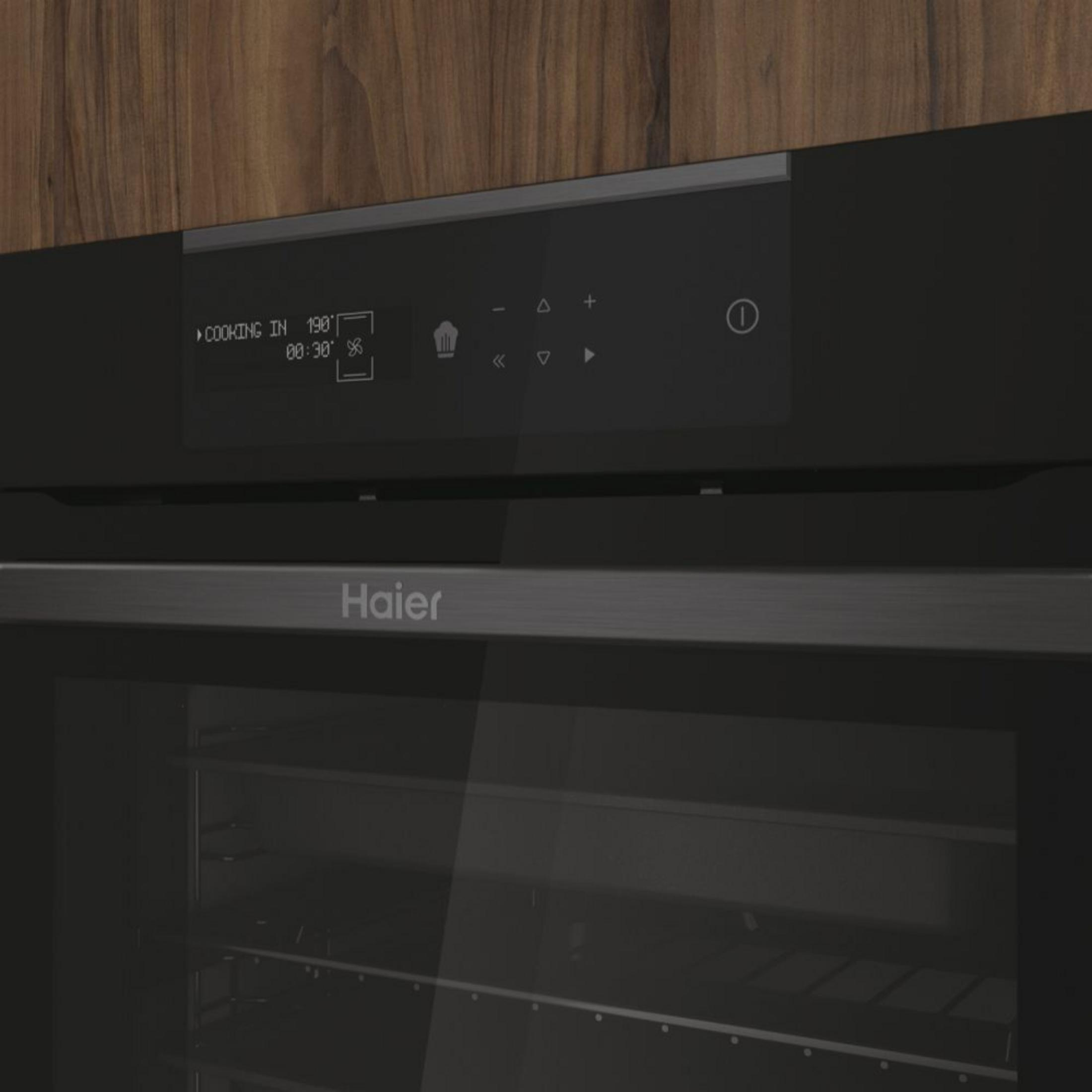 Un horno moderno Haier con frente de cristal negro y pantalla digital.