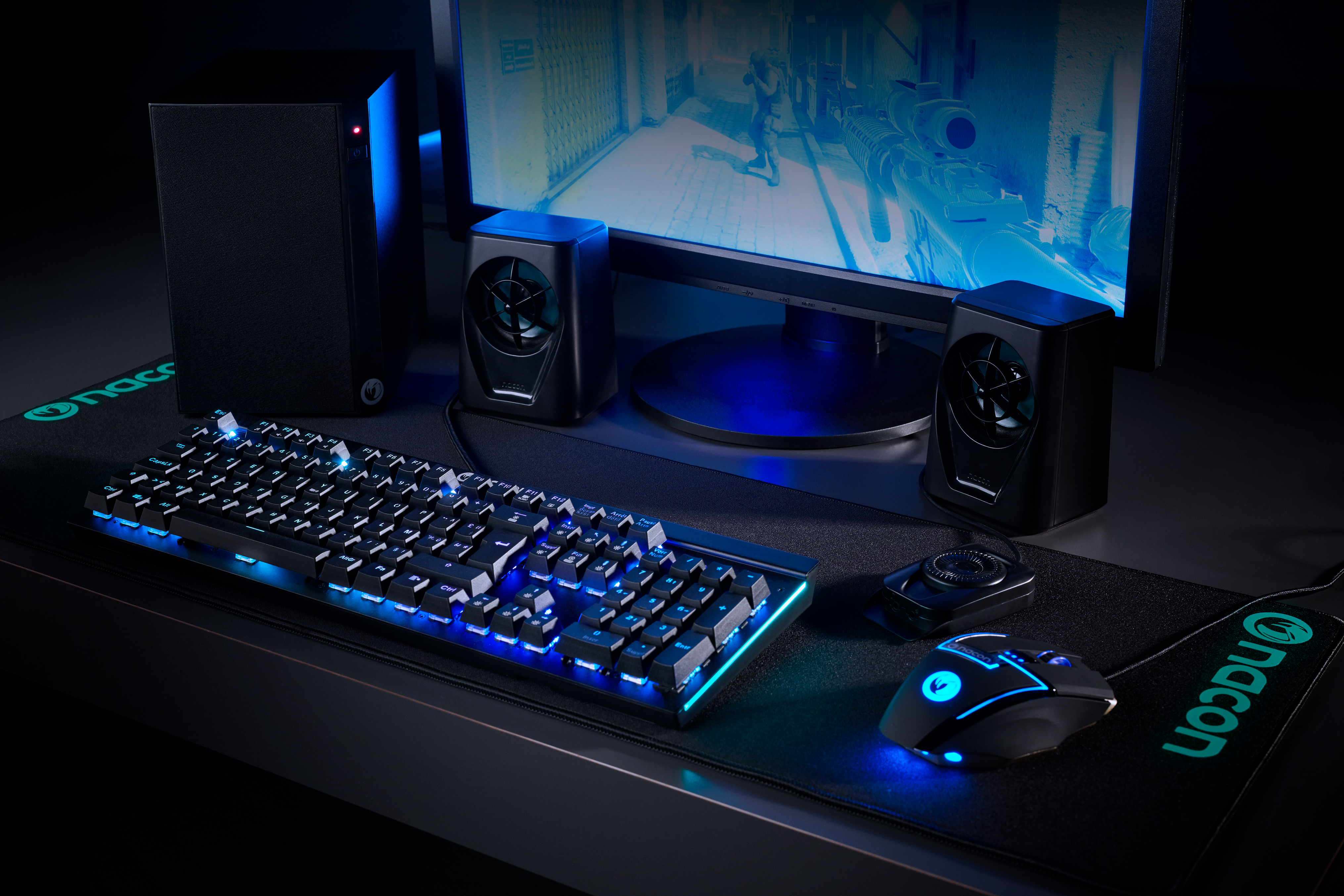 Ein Gaming-Setup mit beleuchteter Tastatur, Maus und Lautsprechern.