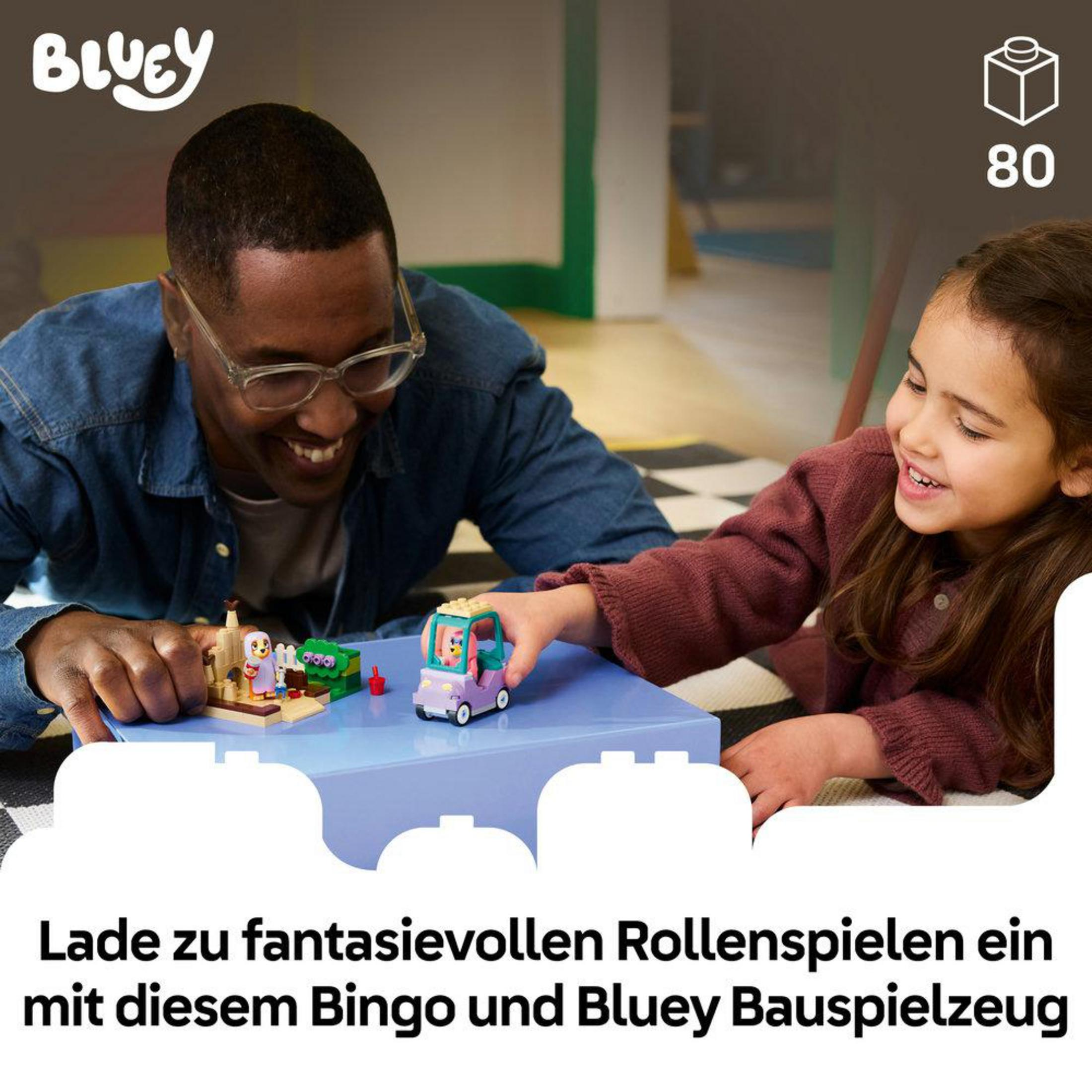 Padre e figlia costruiscono un'auto giocattolo Bluey e una piccola scena.