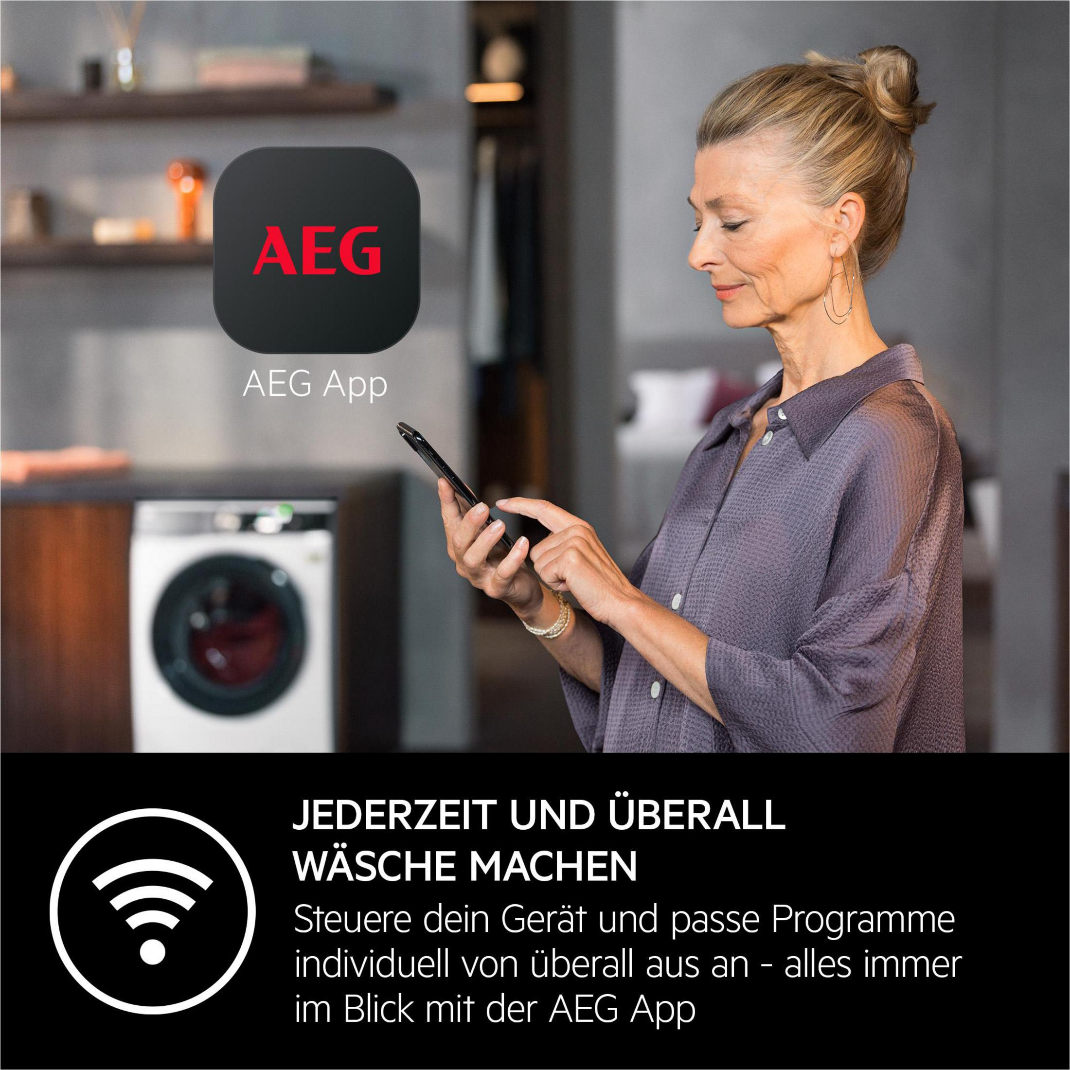 Frau bedient Smartphone vor Waschmaschine mit AEG App.