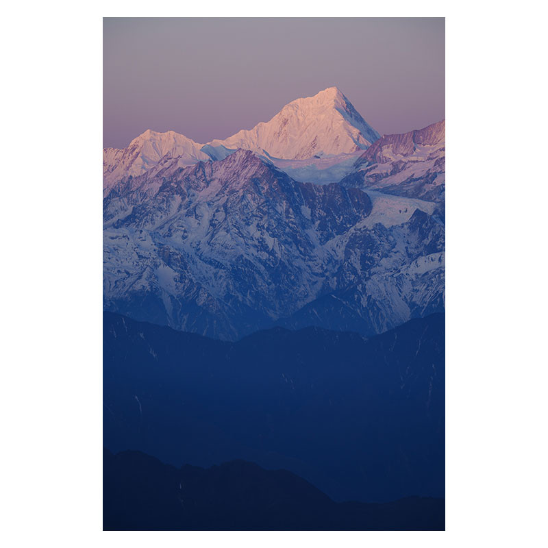 Montañas nevadas bañadas por la luz del atardecer, con sombras azul oscuro.