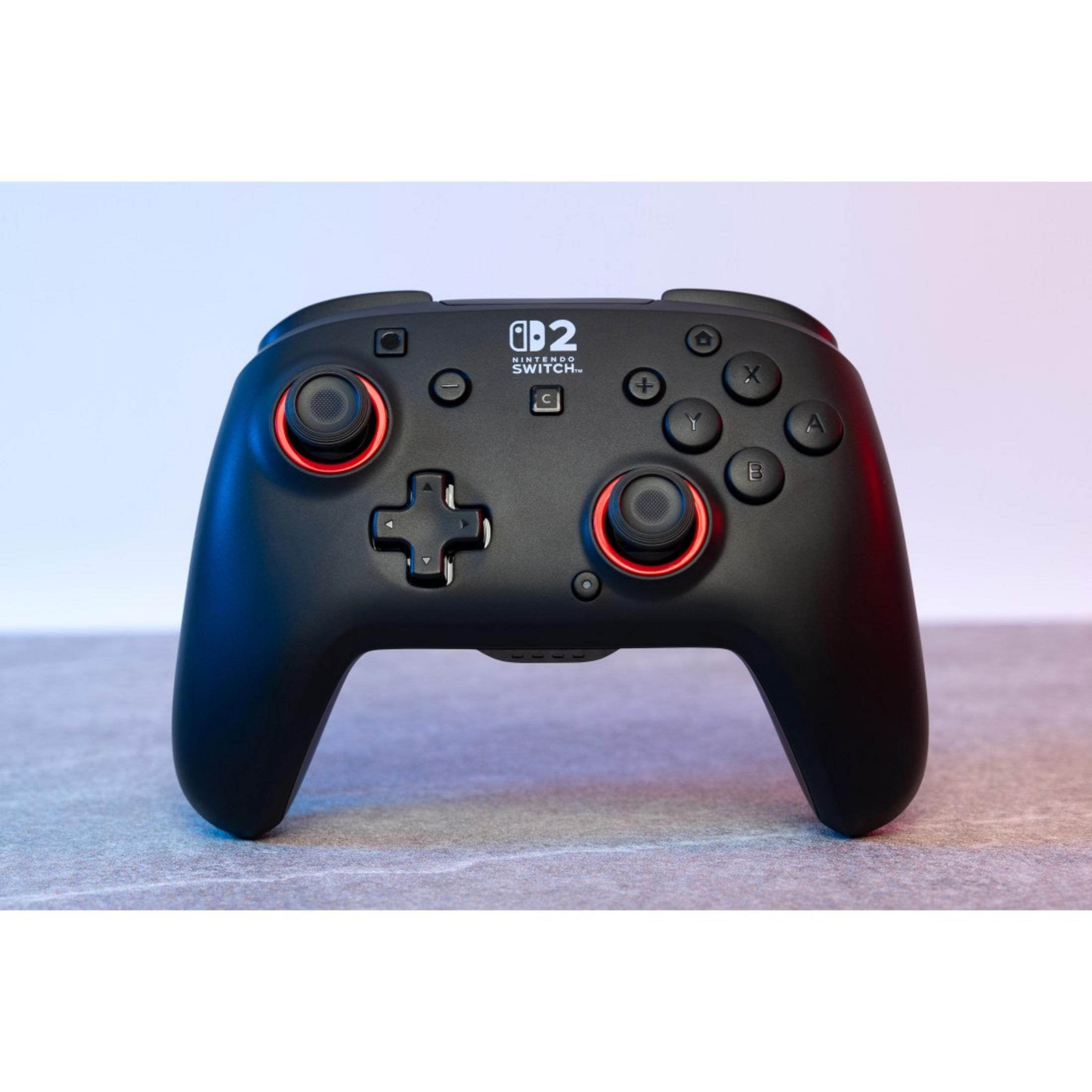 Schwarzer Nintendo Switch Controller mit roten Akzenten auf grauer Oberfläche.