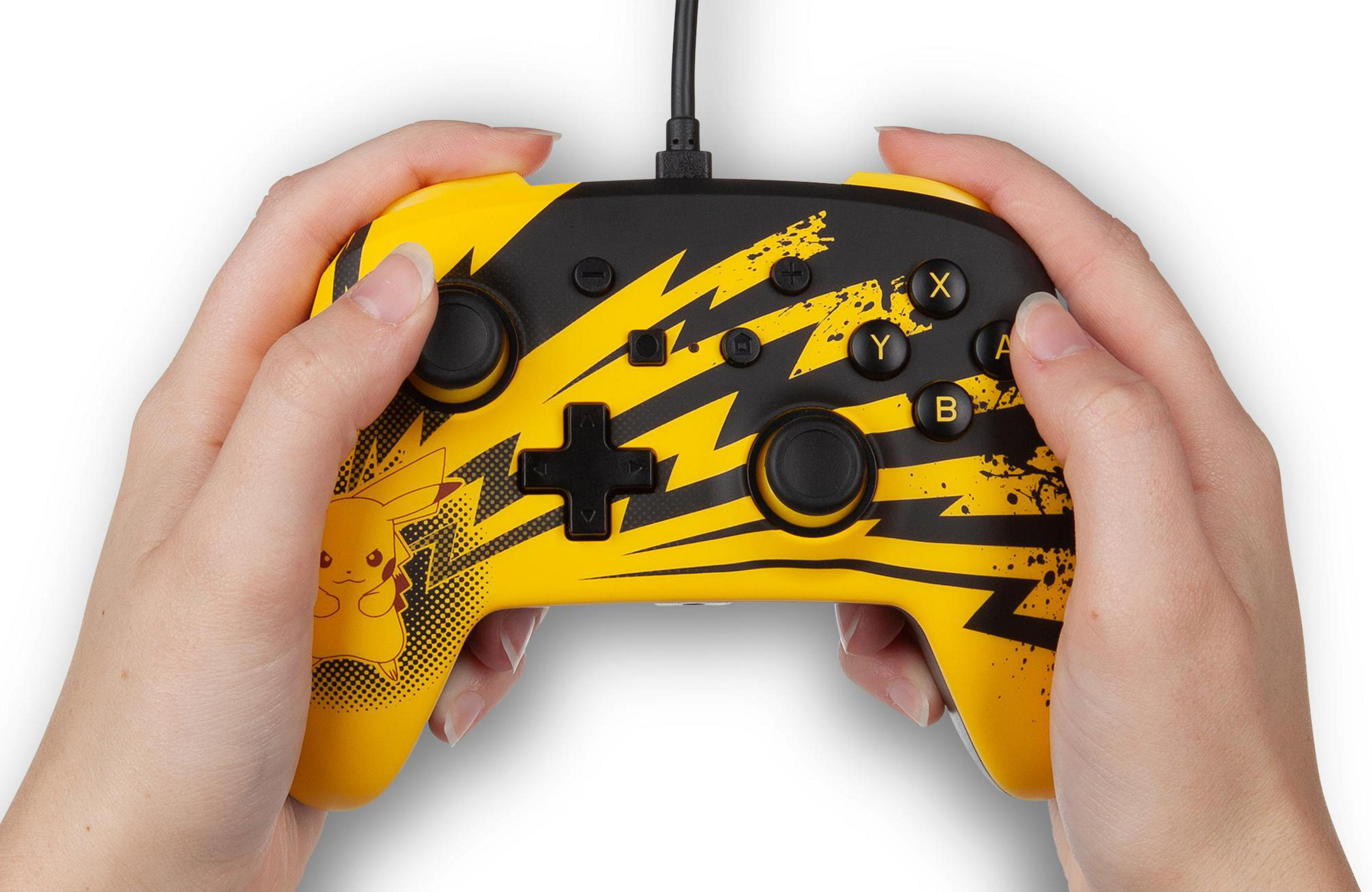 Mani che tengono un controller Pikachu giallo e nero con pulsanti.