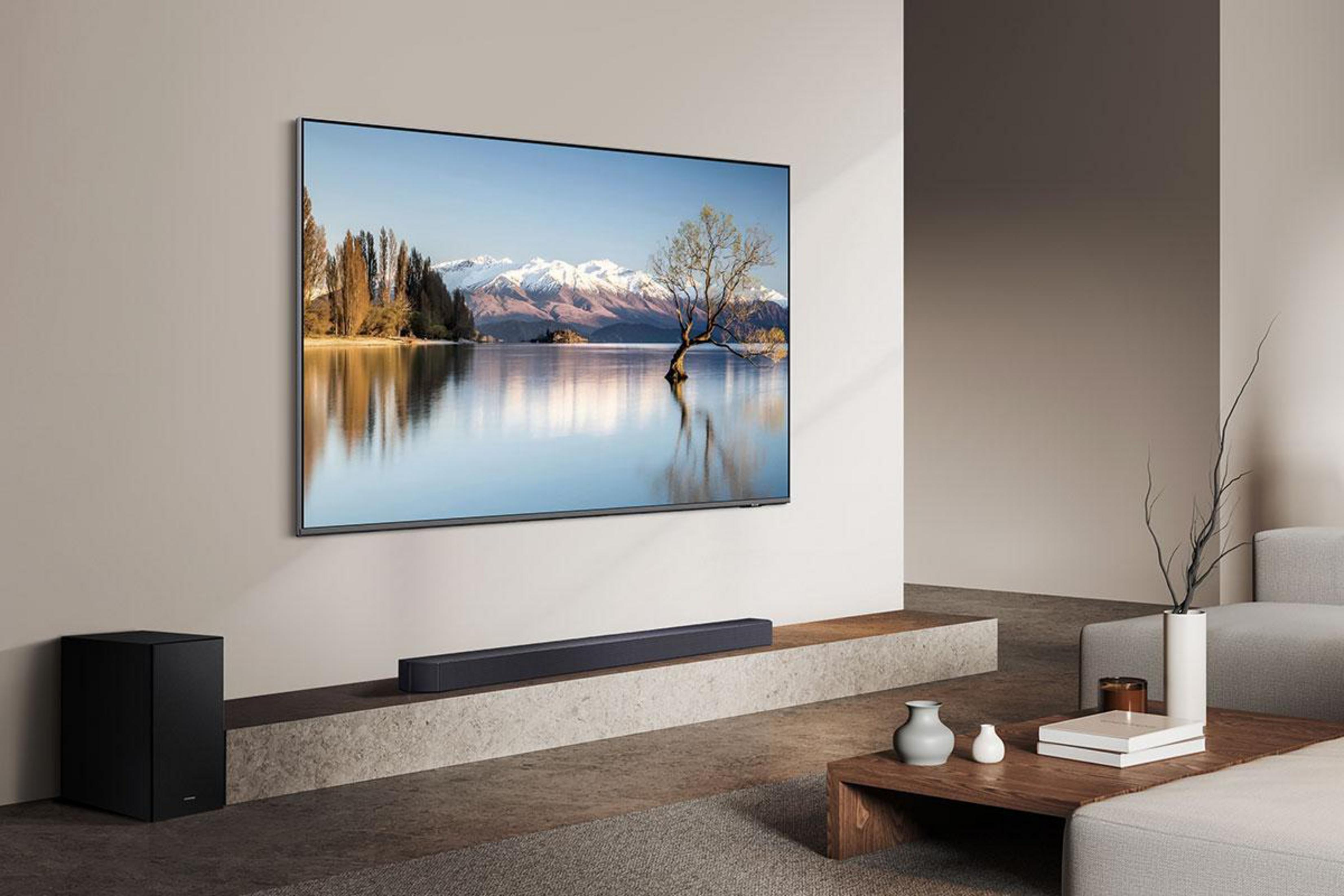 Ein moderner Wohnraum mit einem großen Fernseher, der eine Berglandschaft zeigt.