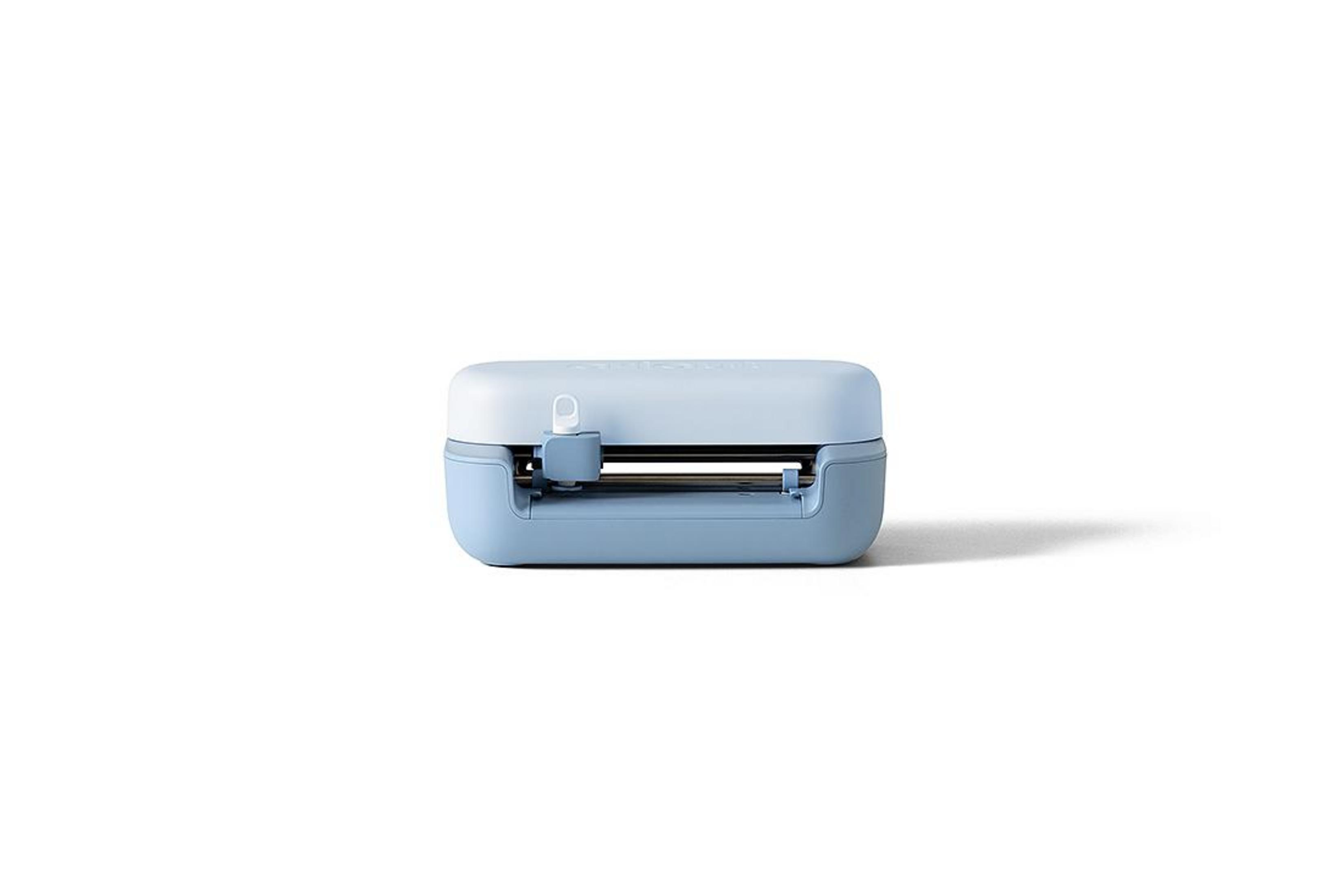 Una máquina de corte azul y azul claro sobre fondo blanco.