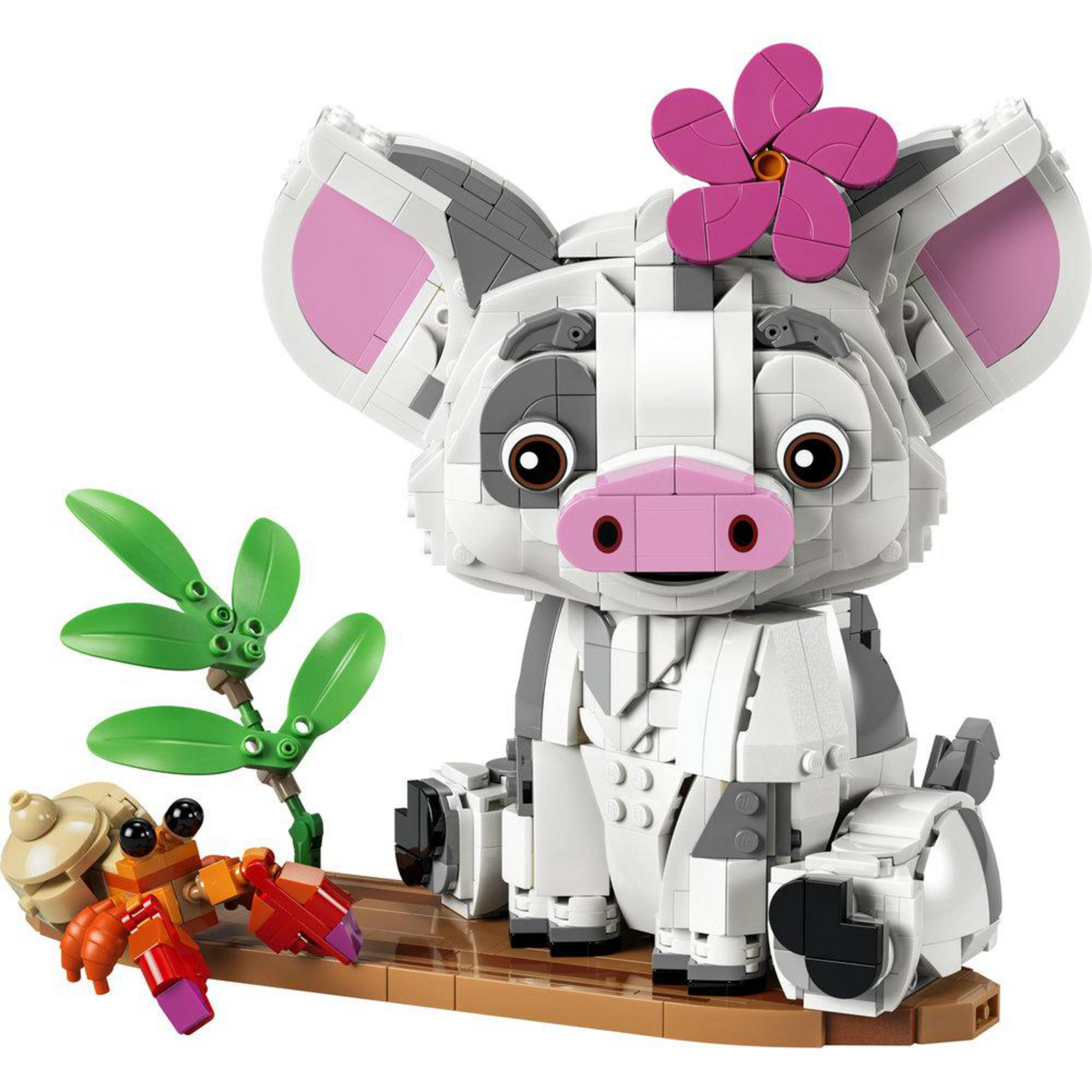 Lego świnka z różowym kwiatkiem na głowie siedzi obok Lego kraba i zielonych liści.
