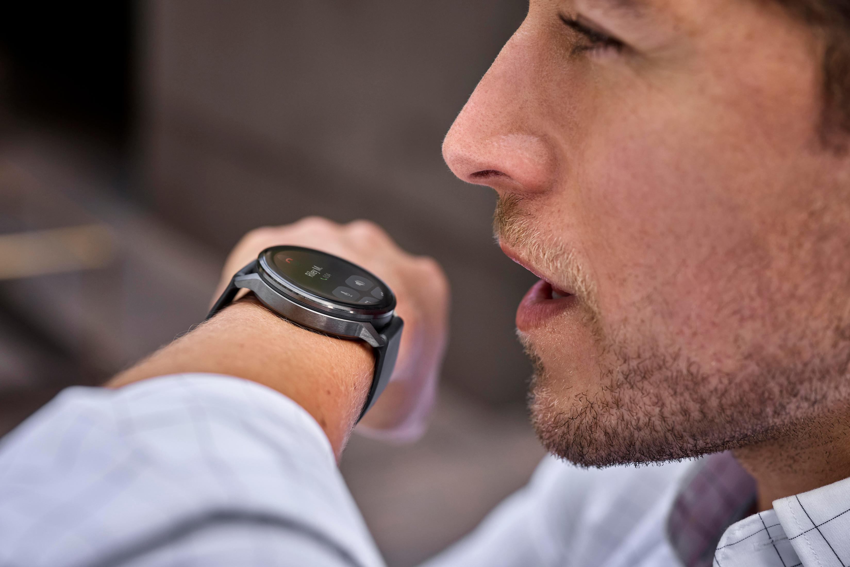 Hombre con camisa blanca mira smartwatch con llamada entrante de Riley M.