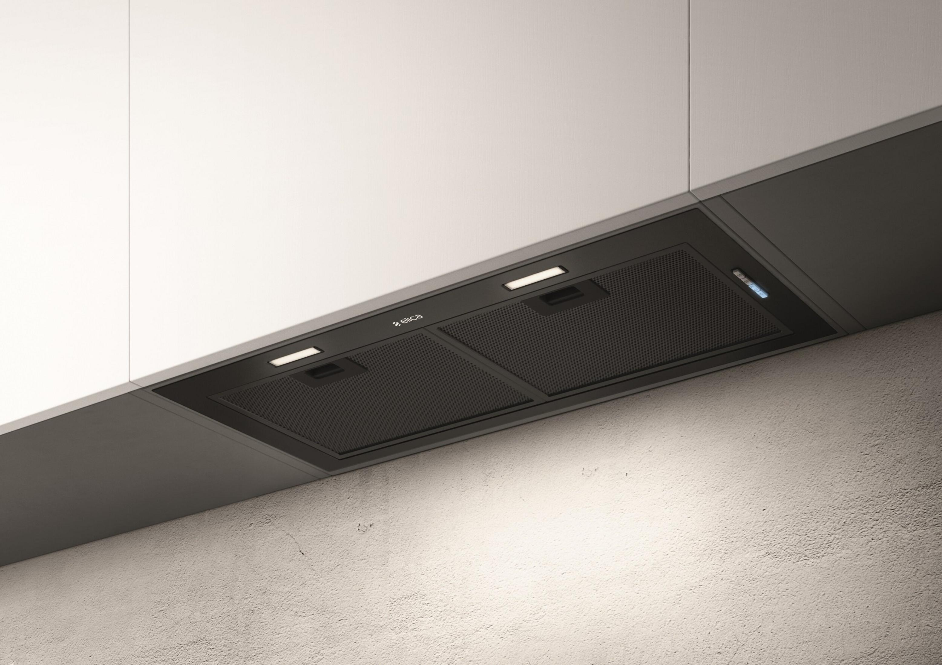 Una cappa da cucina nera con luci sopra un piano cottura.