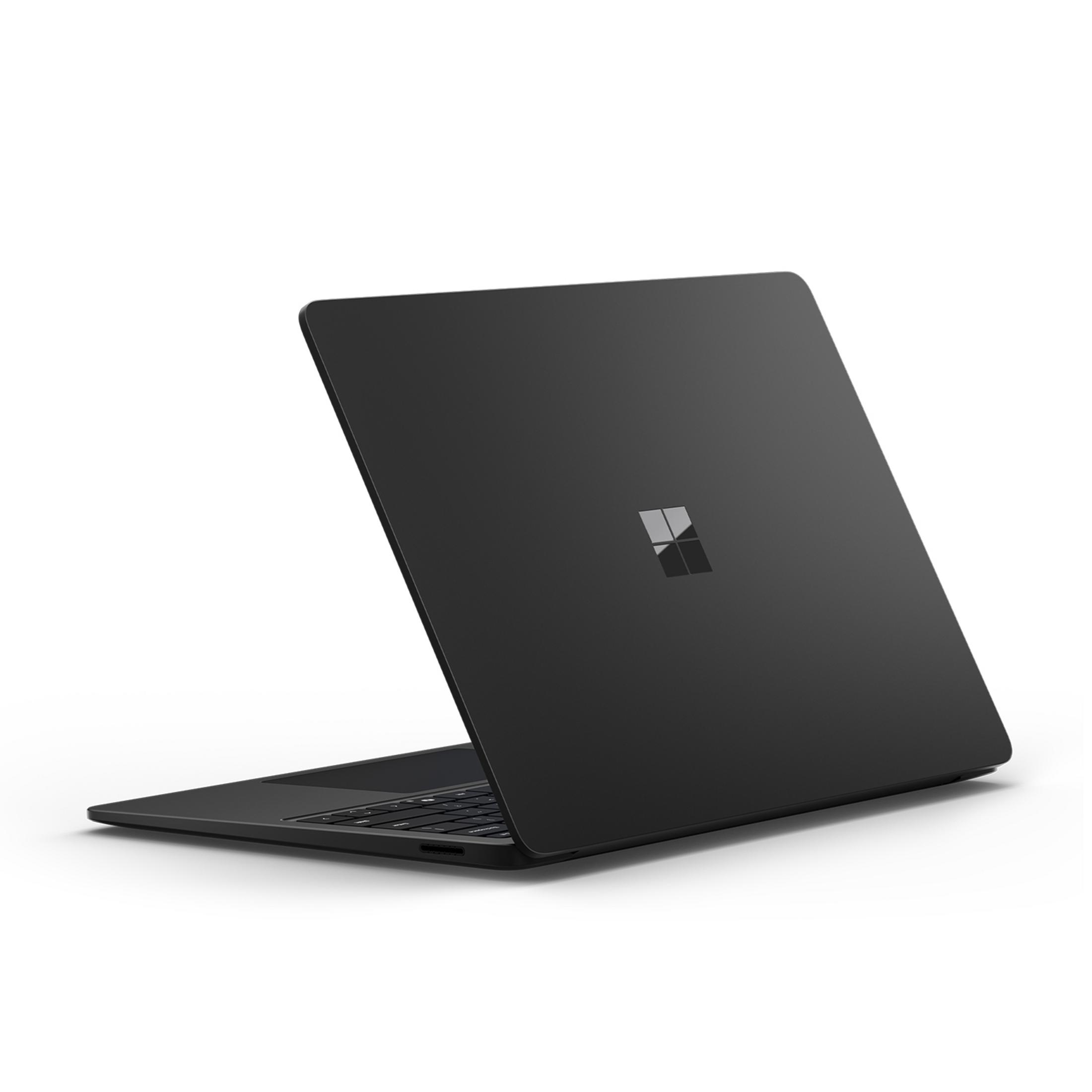 Czarny laptop z logo Microsoft na pokrywie, pokazany od tyłu.