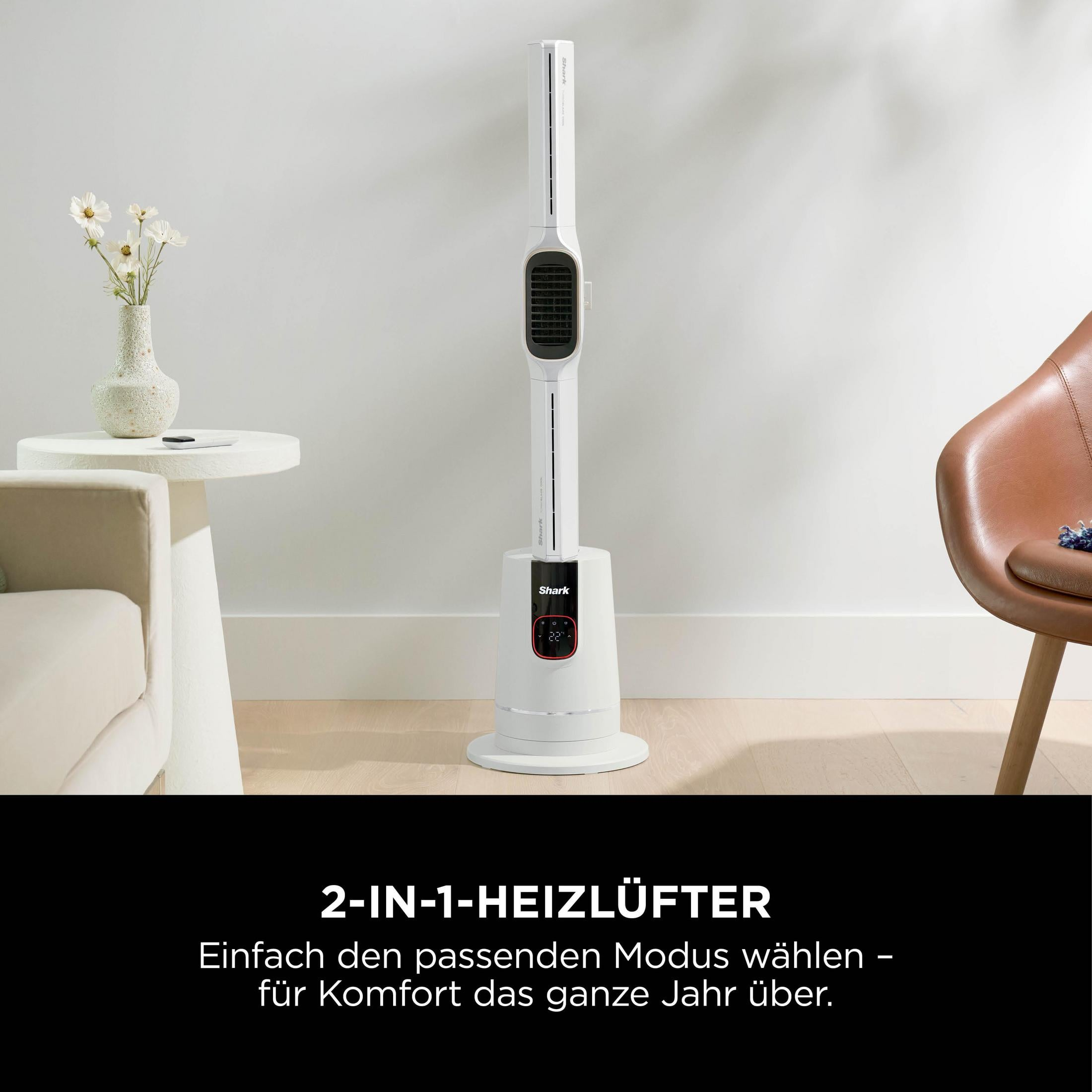 Ein weißer Shark Heizlüfter steht auf einem Holzboden, neben einem Sessel.