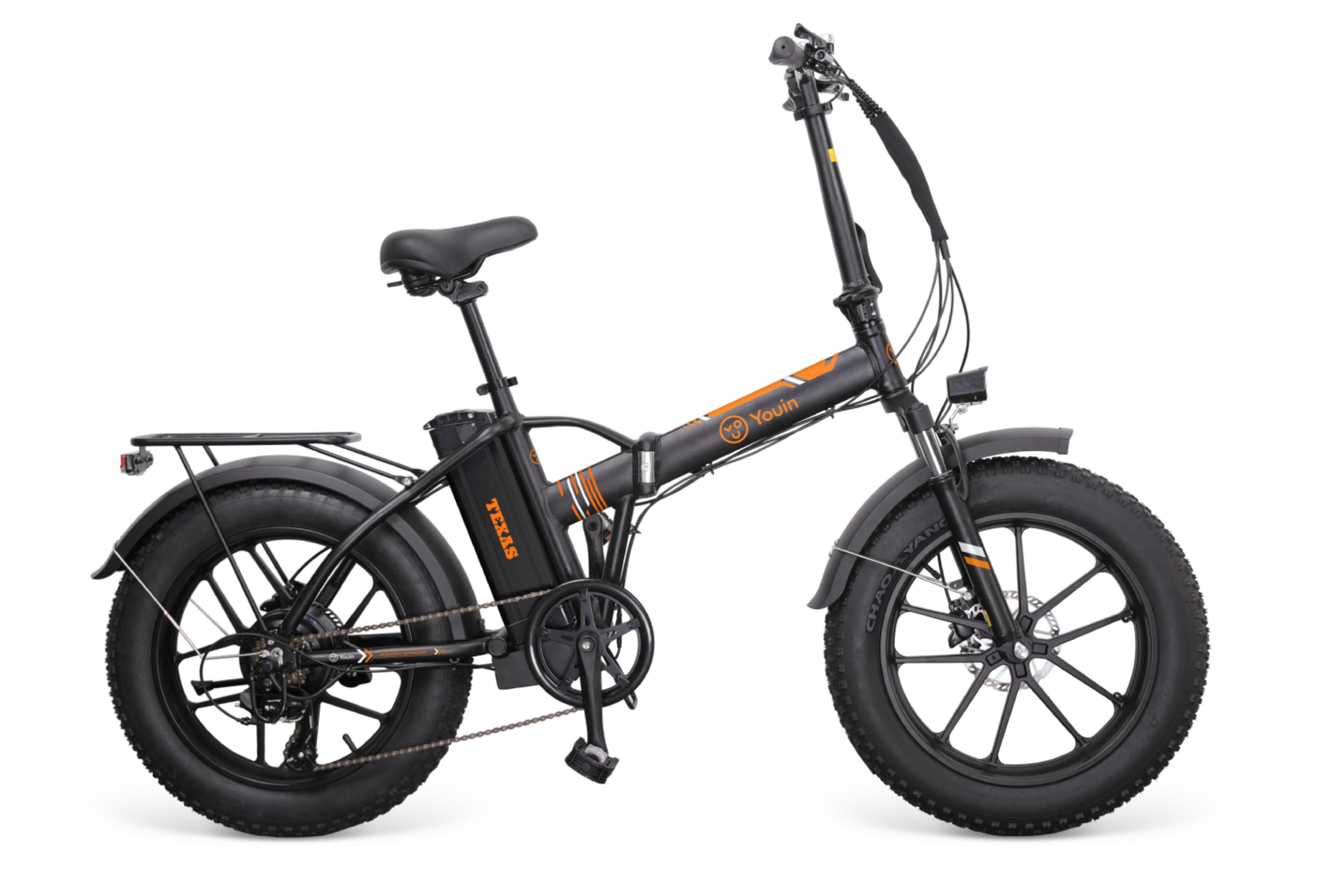 Ein schwarzes faltbares E-Bike mit breiten Reifen, orangefarbenen Akzenten und Gepäckträger.