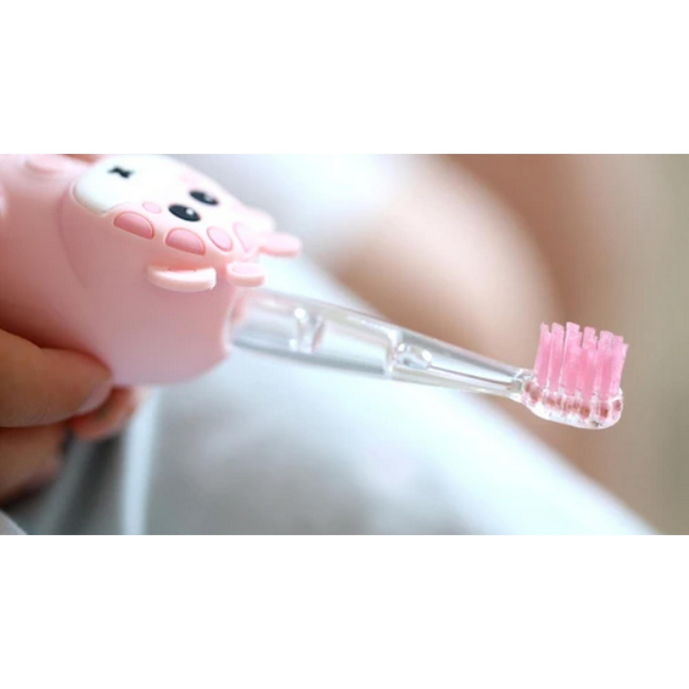 Uno spazzolino rosa a forma di maialino con setole rosa tenuto da una mano.