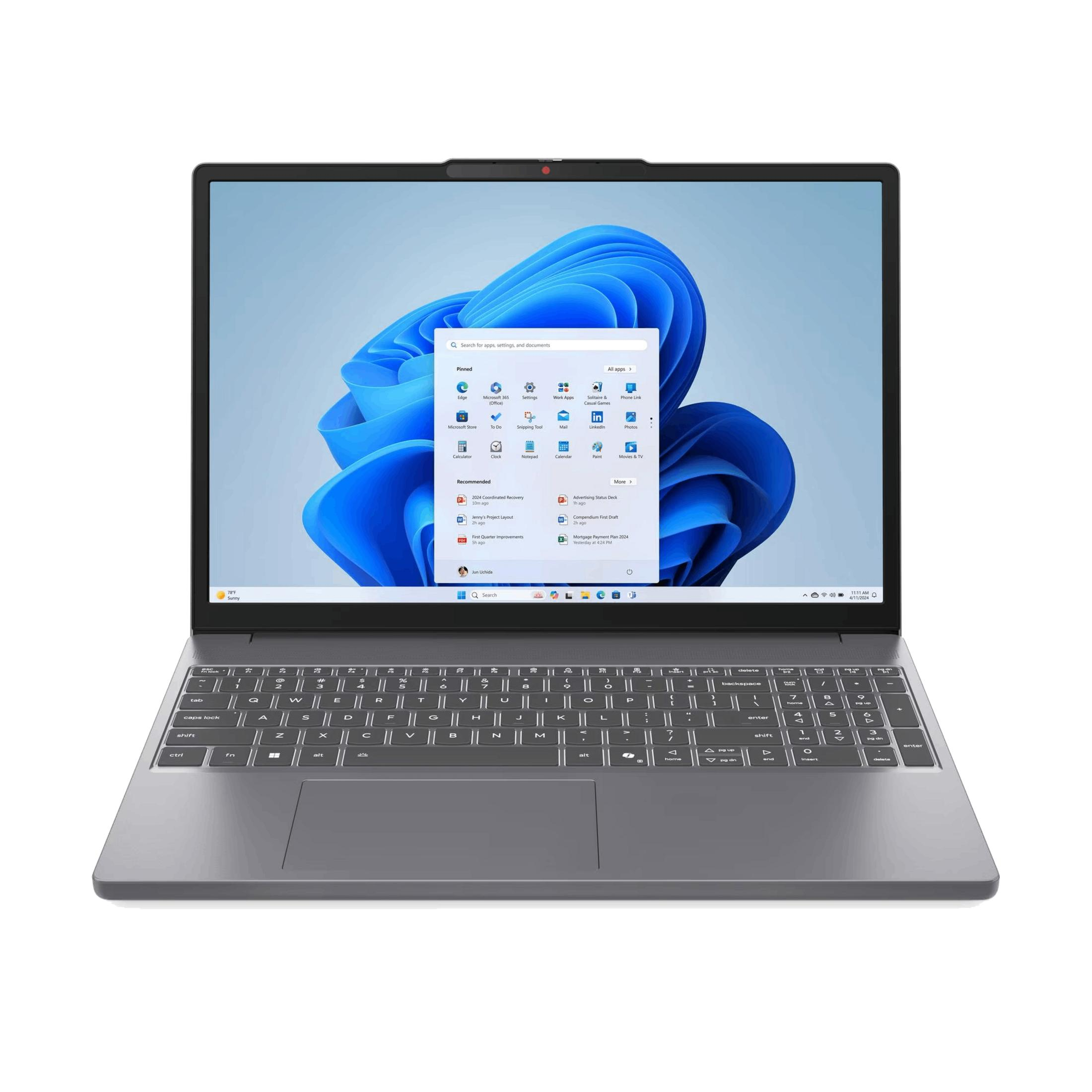 Un portátil cerrado y oscuro con pantalla brillante mostrando el menú Inicio de Windows 11.