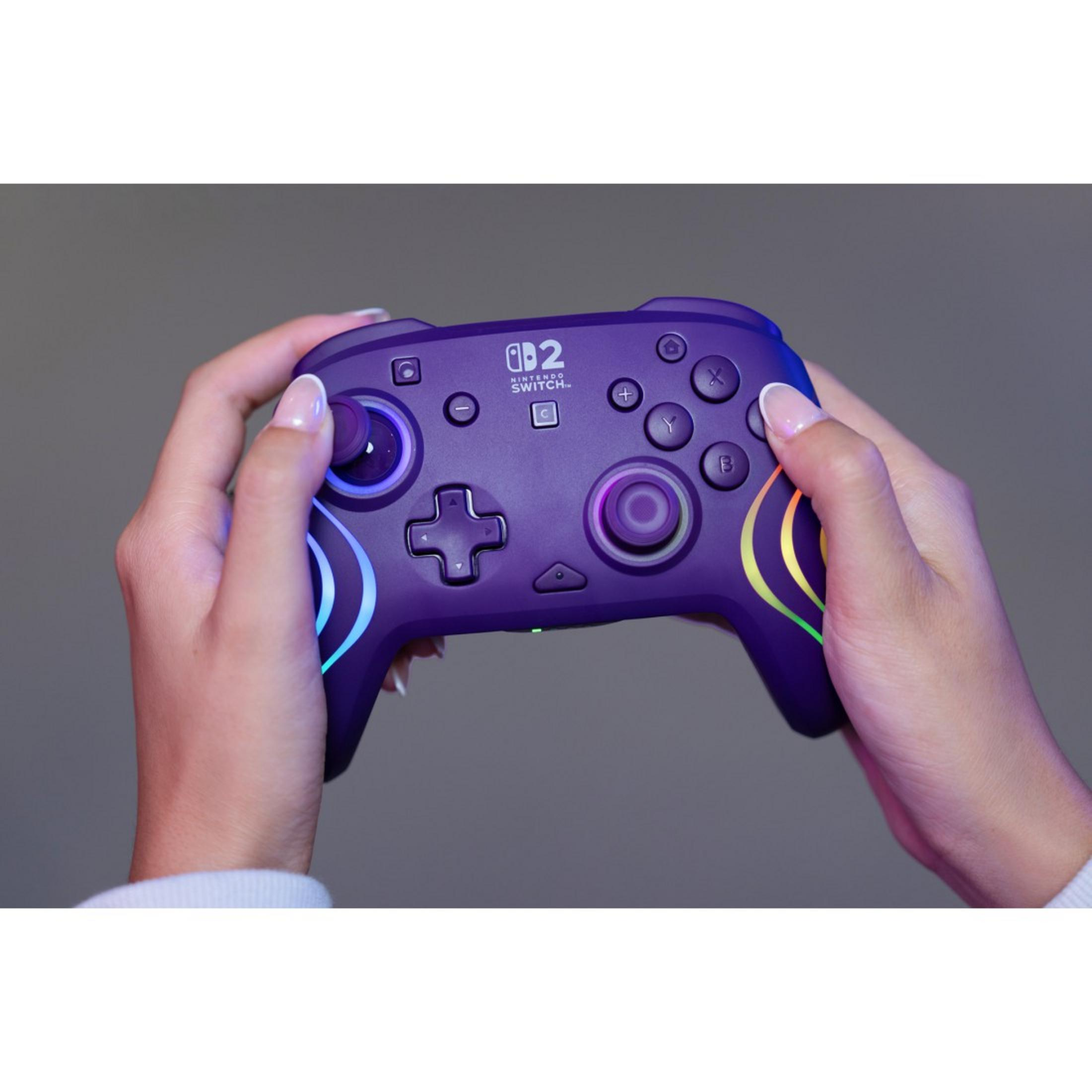 Controller viola Nintendo Switch con luci colorate tenuto dalle mani.