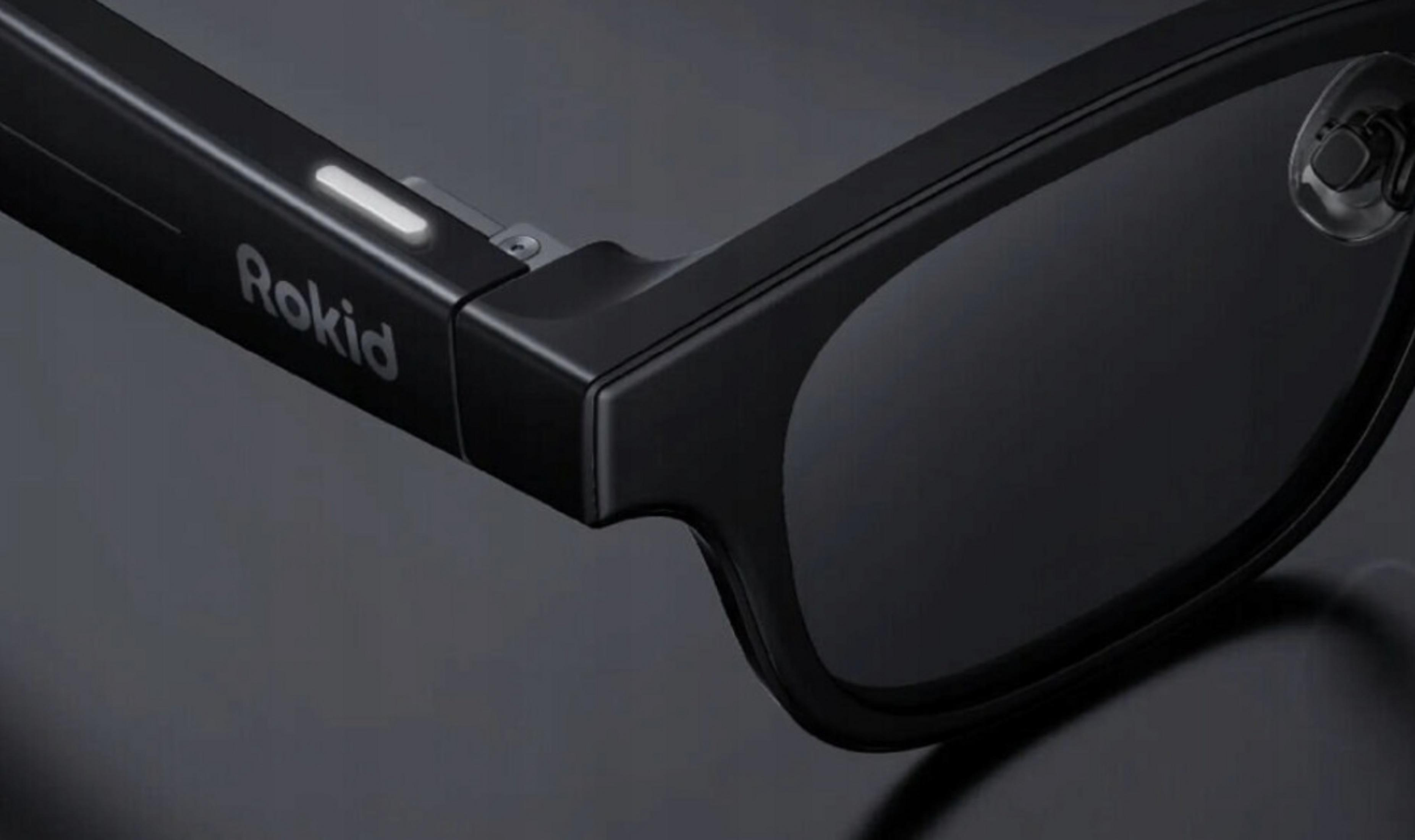 Primer plano de gafas inteligentes negras con logo 'Rokid' y luz indicadora iluminada.