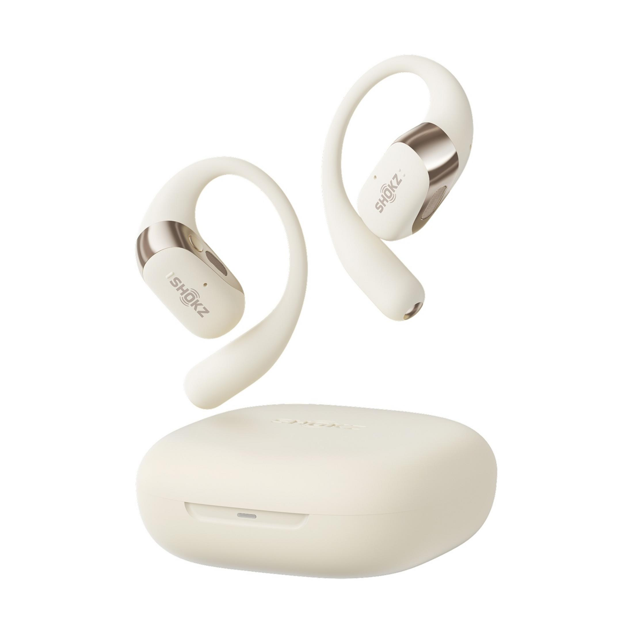 Dos auriculares Shokz blancos con detalles dorados y un estuche de carga a juego.