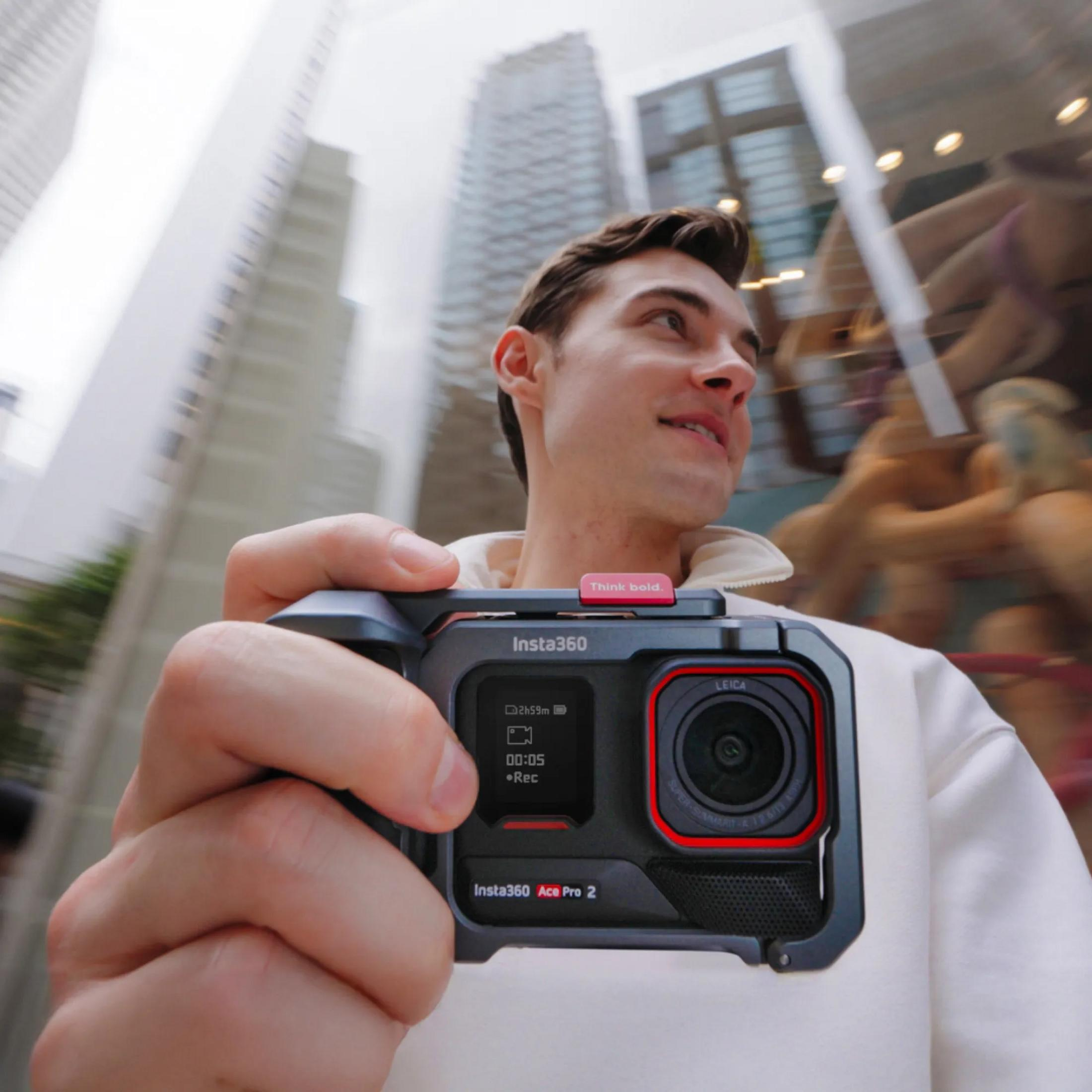 Ein Mann hält eine Insta360 Ace Pro 2 Kamera vor einer unscharfen Stadtkulisse.
