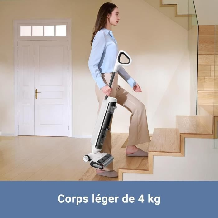 Una donna porta un aspirapolvere leggero sulle scale.