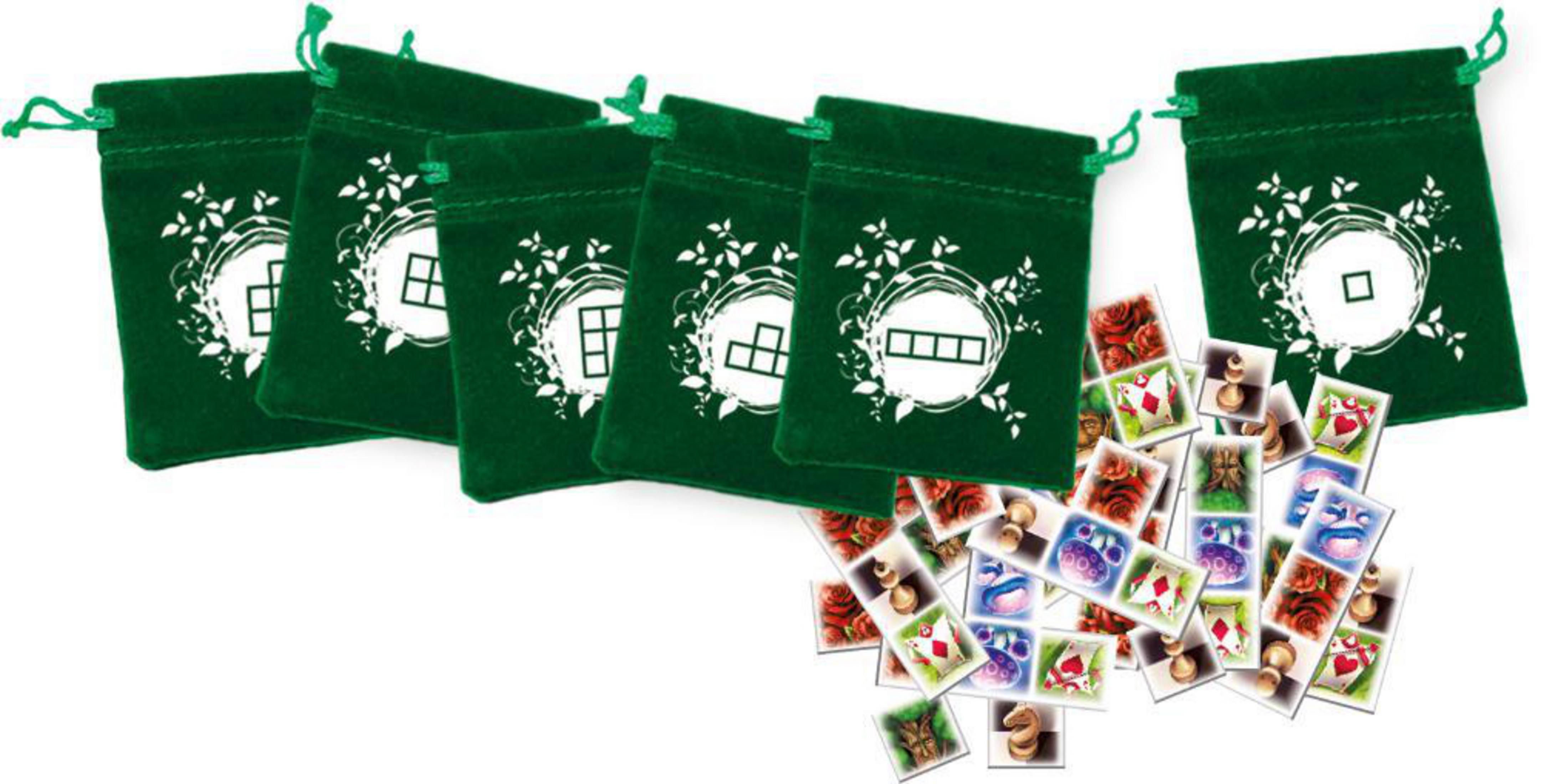 Sechs grüne Beutel mit weißen Symbolen und verstreute Spielkarten mit verschiedenen Bildern.